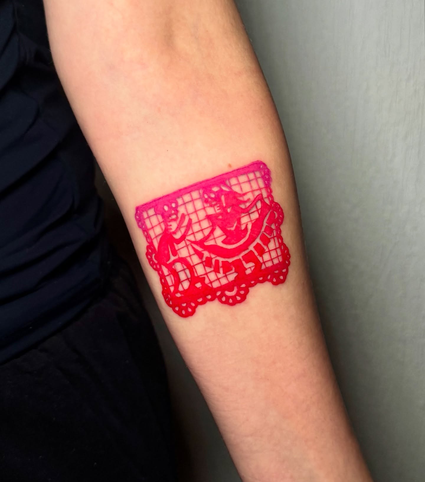 Papel picado Chicano tattoo on the forearm by Mishel Castro