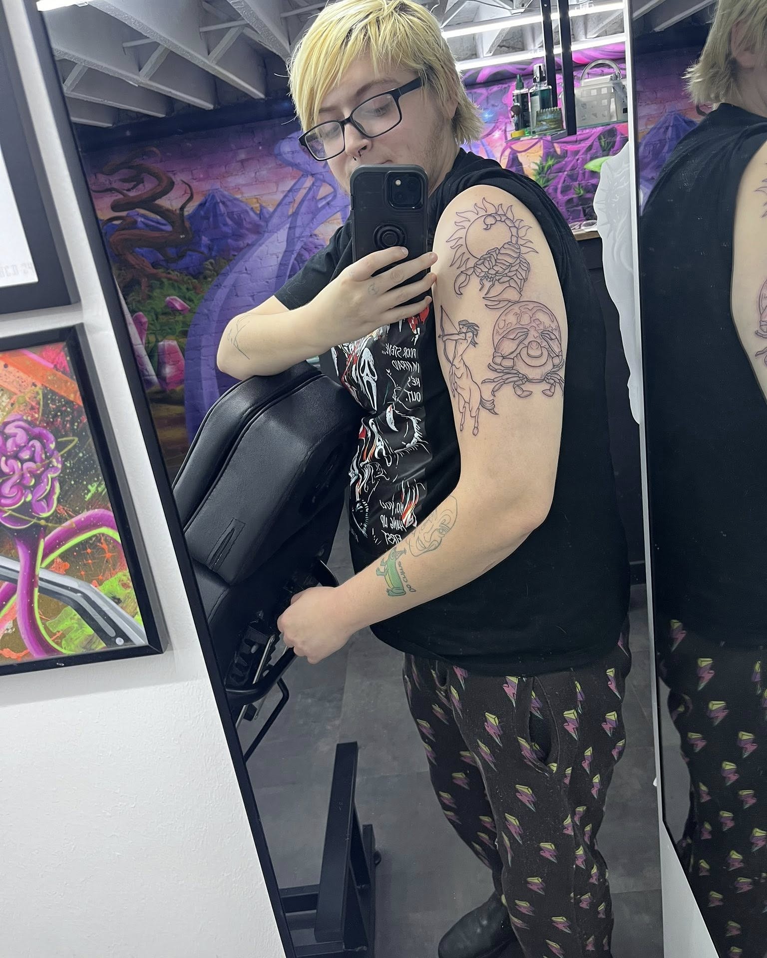 Astronaut and sun dotwork tattoo on the upper arm by Sav