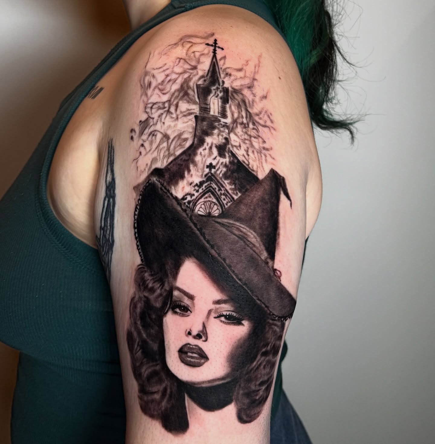 Woman wearing hat realism tattoo on the shoulder by Tori Bent