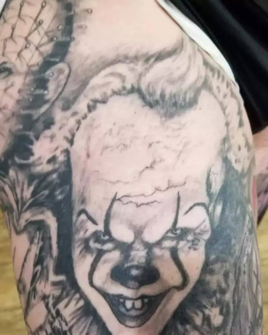 Pennywise the clown realism tattoo on the upper arm by Russell Lucas