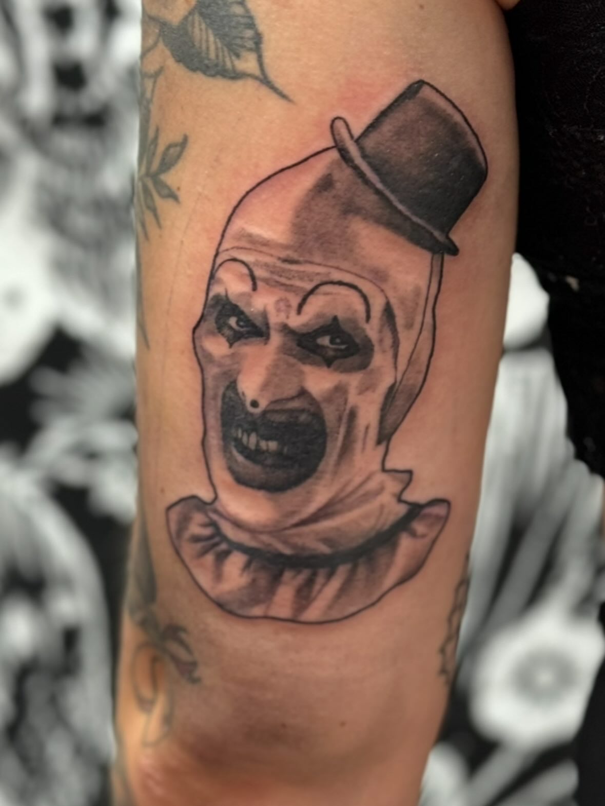 Clown black and grey tattoo on the forearm by Robbie Bryant