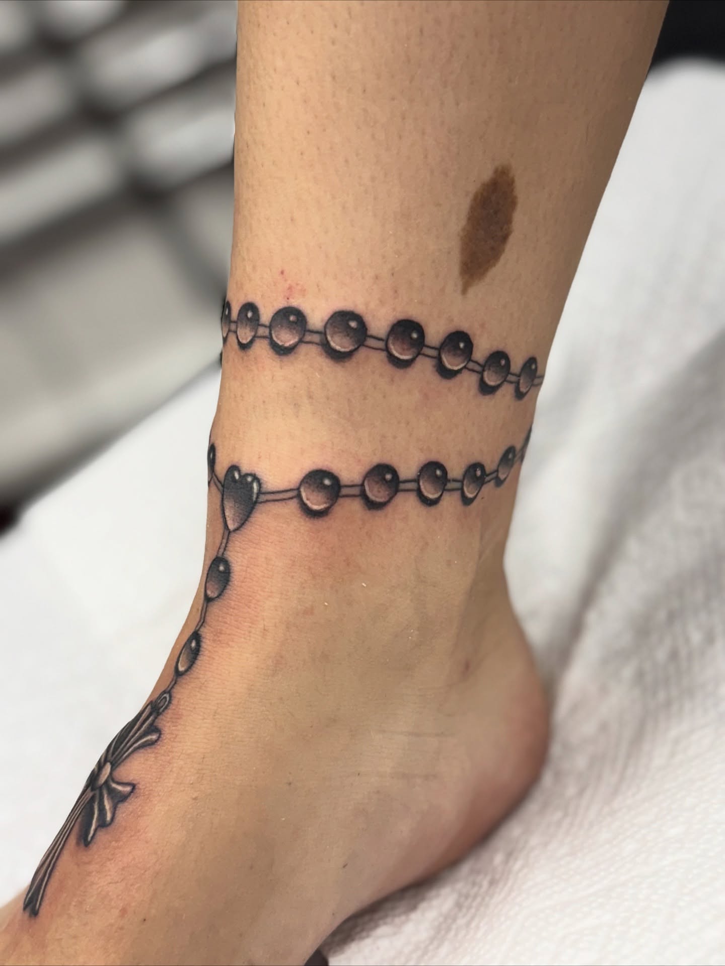 Rosary black and grey tattoo on the foot by Damian Sandoval