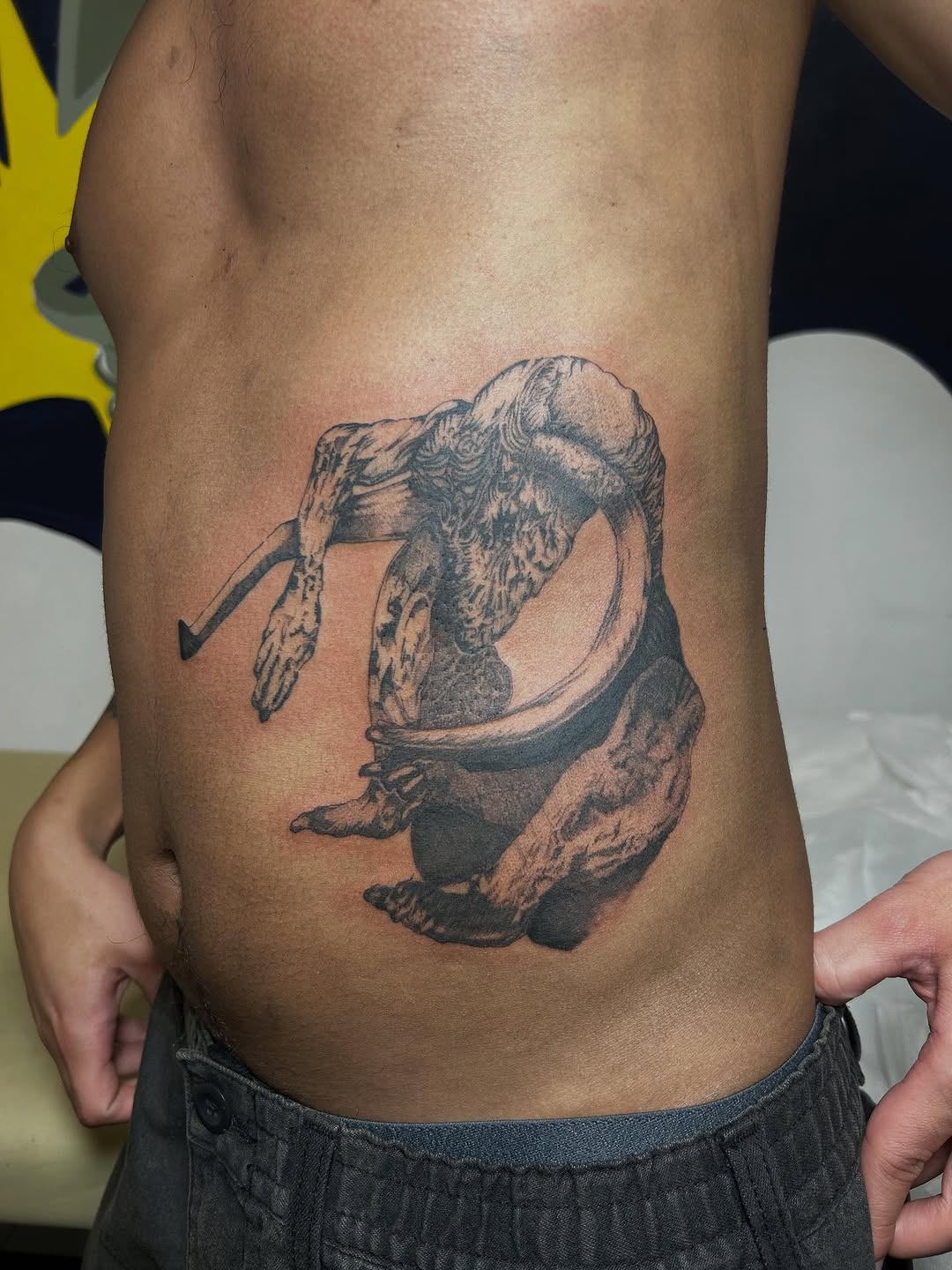 Figure in a mirror sketch tattoo on the ribs by Jadin Nichols