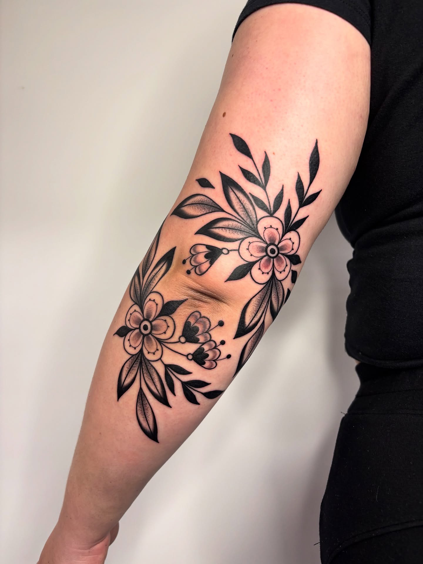 Floral arrangement American traditional tattoo on the forearm by Victoria Bacon