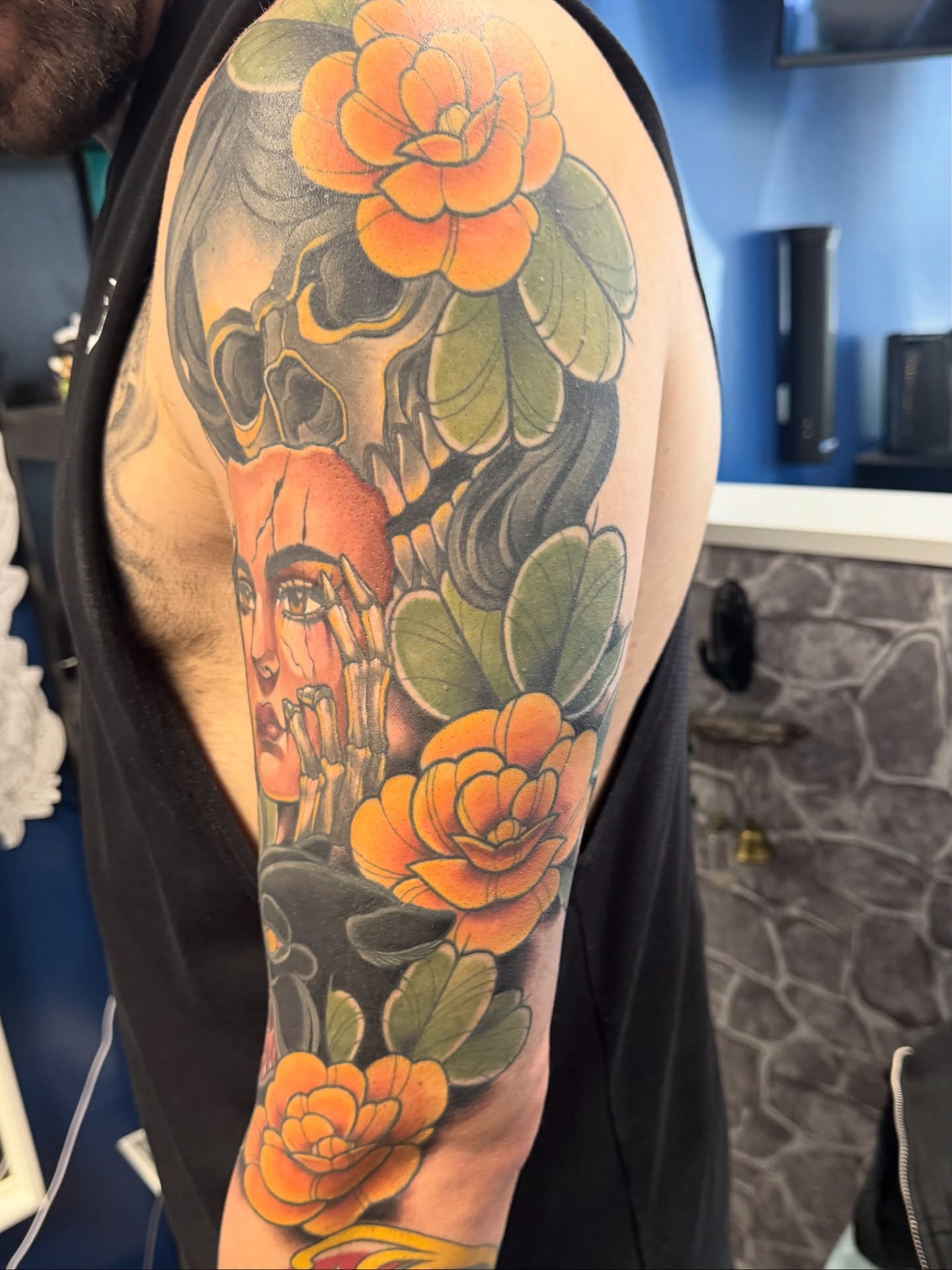 Floral and woman's face American traditional tattoo on the upper arm by Bri