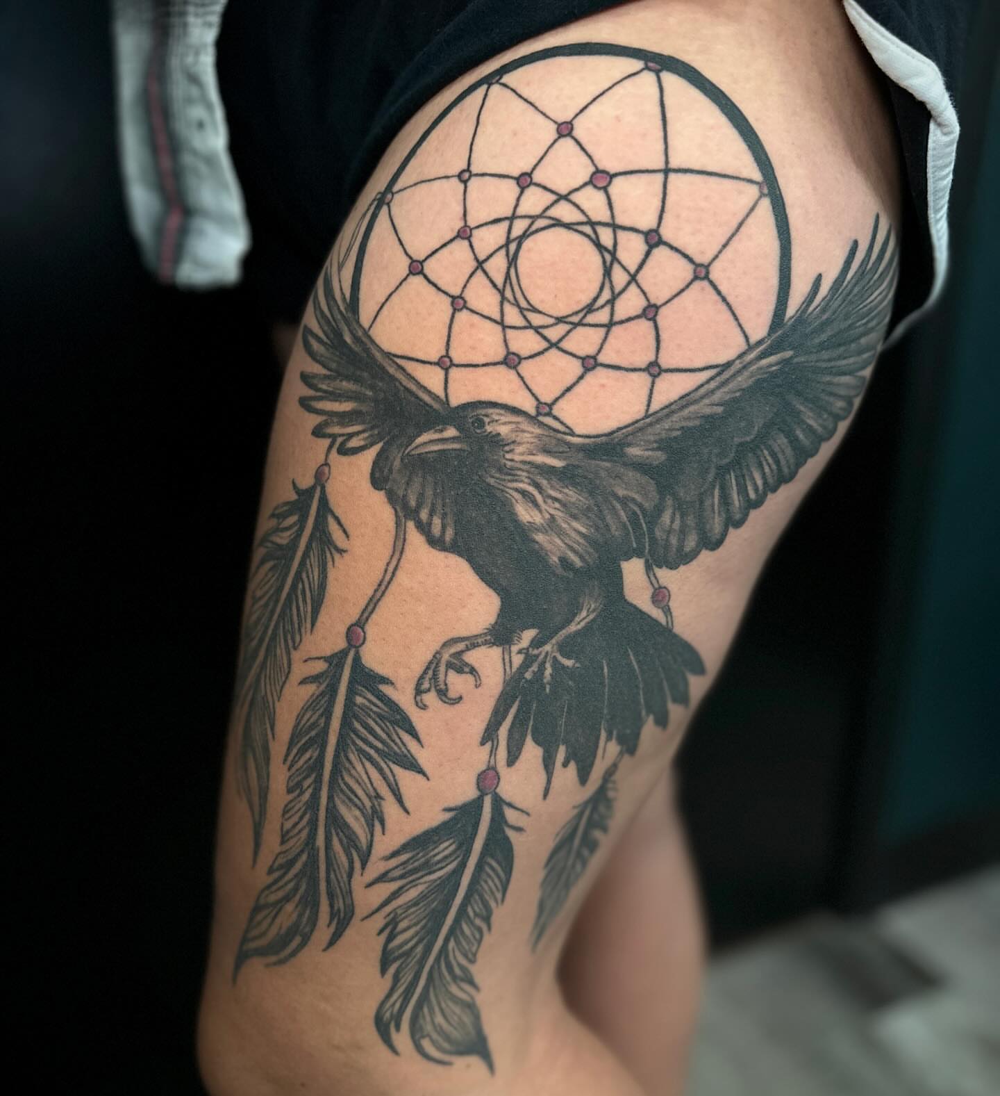 Raven and dreamcatcher geometric tattoo on the thigh by Mika'la Berry