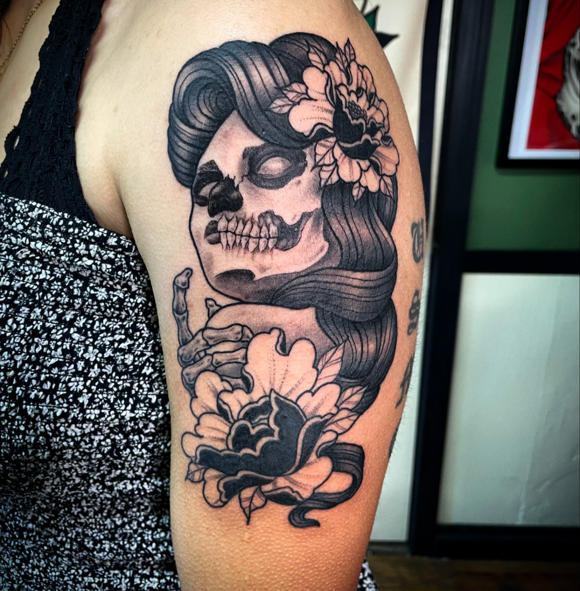 Skull with flowers realism tattoo on the forearm by San Diego Tattoo Artist