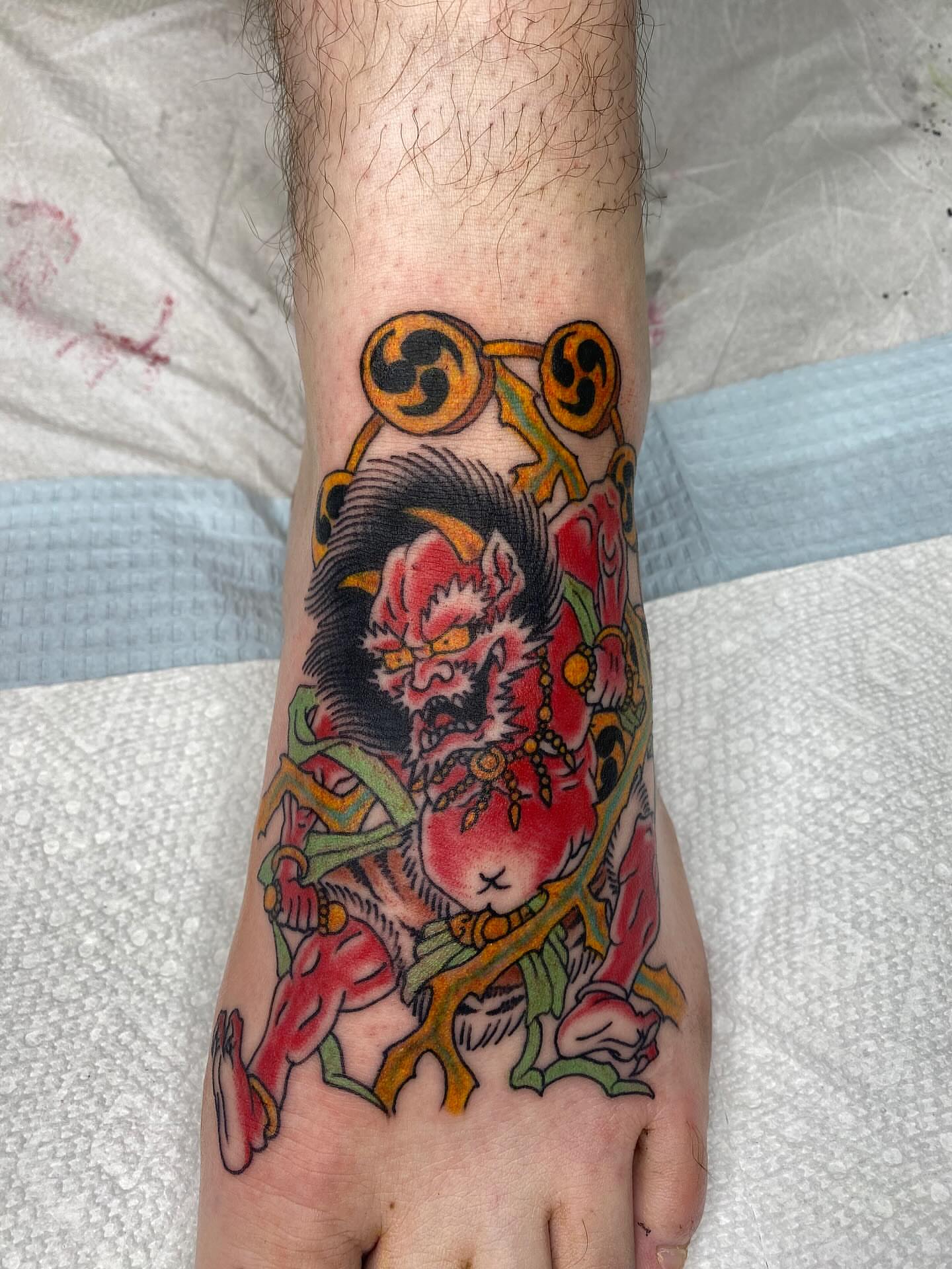 Demon with peach japanese irezumi tattoo on the foot by Thomas Cook