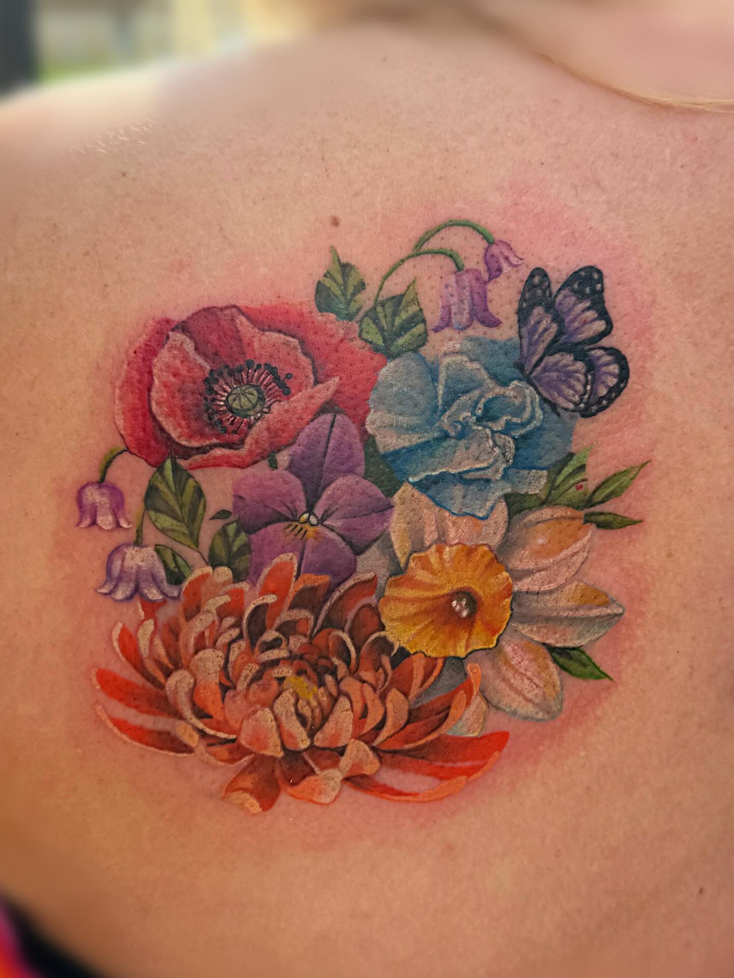 Floral bouquet realism tattoo on the shoulder by Elly Bordwell