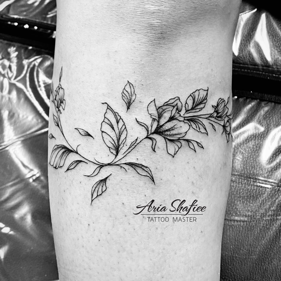 Floral branch fine line tattoo on the forearm by Aria Shafiee