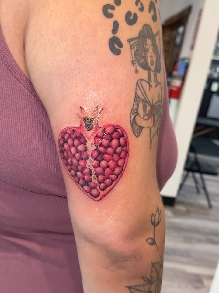 Pomegranate realism tattoo on the forearm by Nathalie Briseno