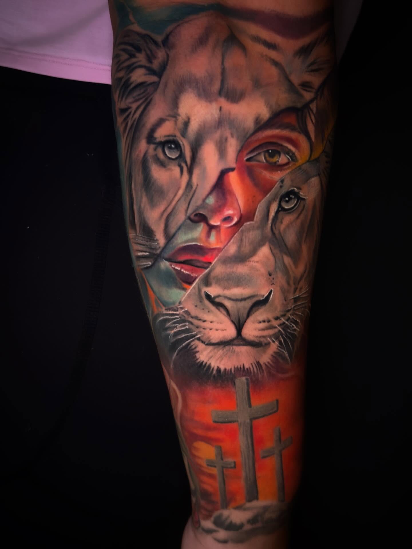 Lion and cross realism tattoo on the forearm by Eric Zuluaga