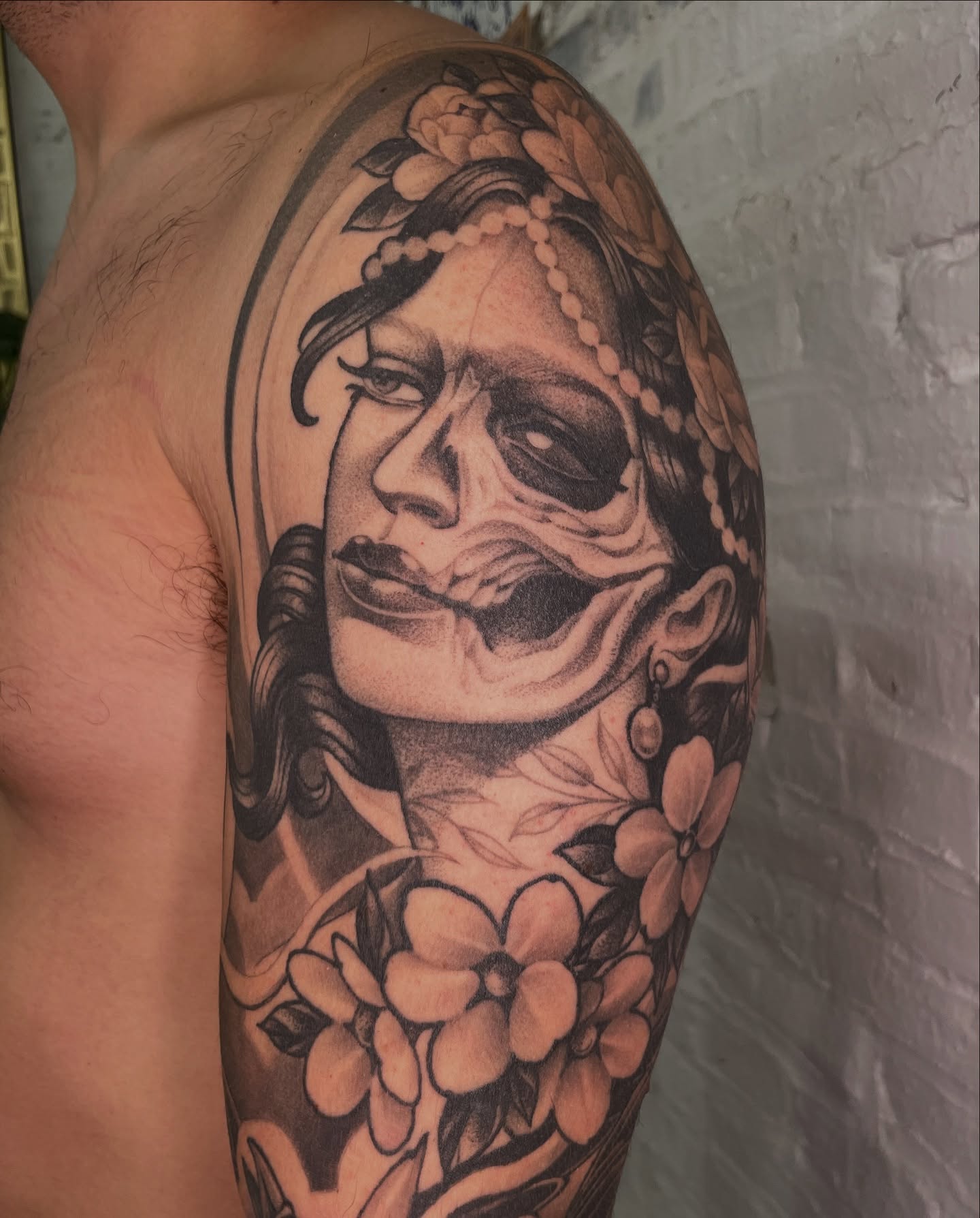 Woman with floral crown realism tattoo on the upper arm by Collie Mills, Philadelphia, Pennsylvania