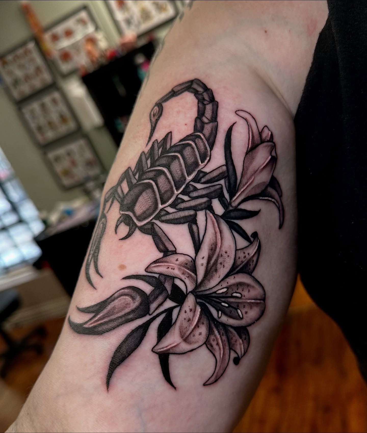 Scorpion and lilies black and grey tattoo on the forearm by Marisa Biddle