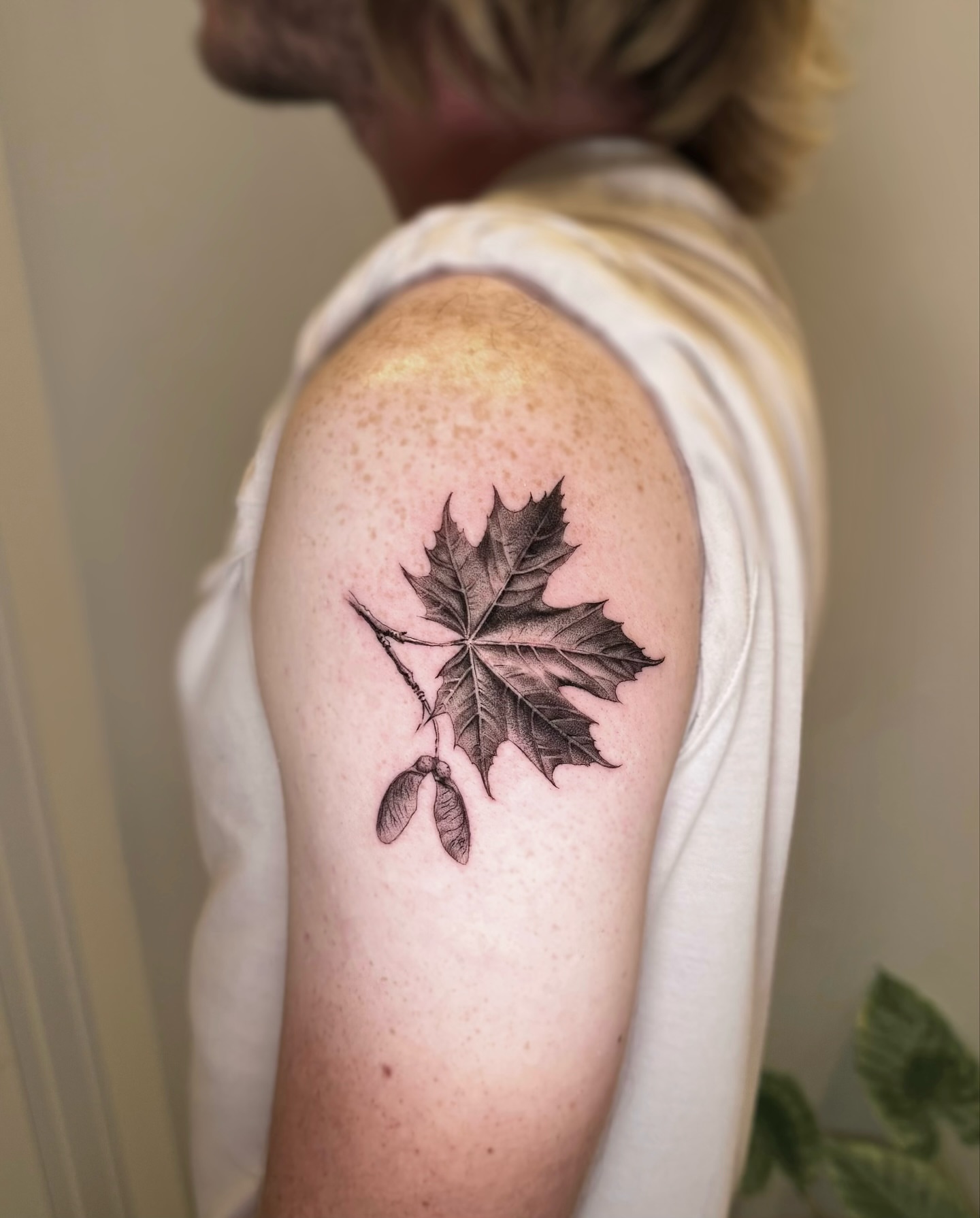 Maple leaf realism tattoo on the shoulder by Oxana