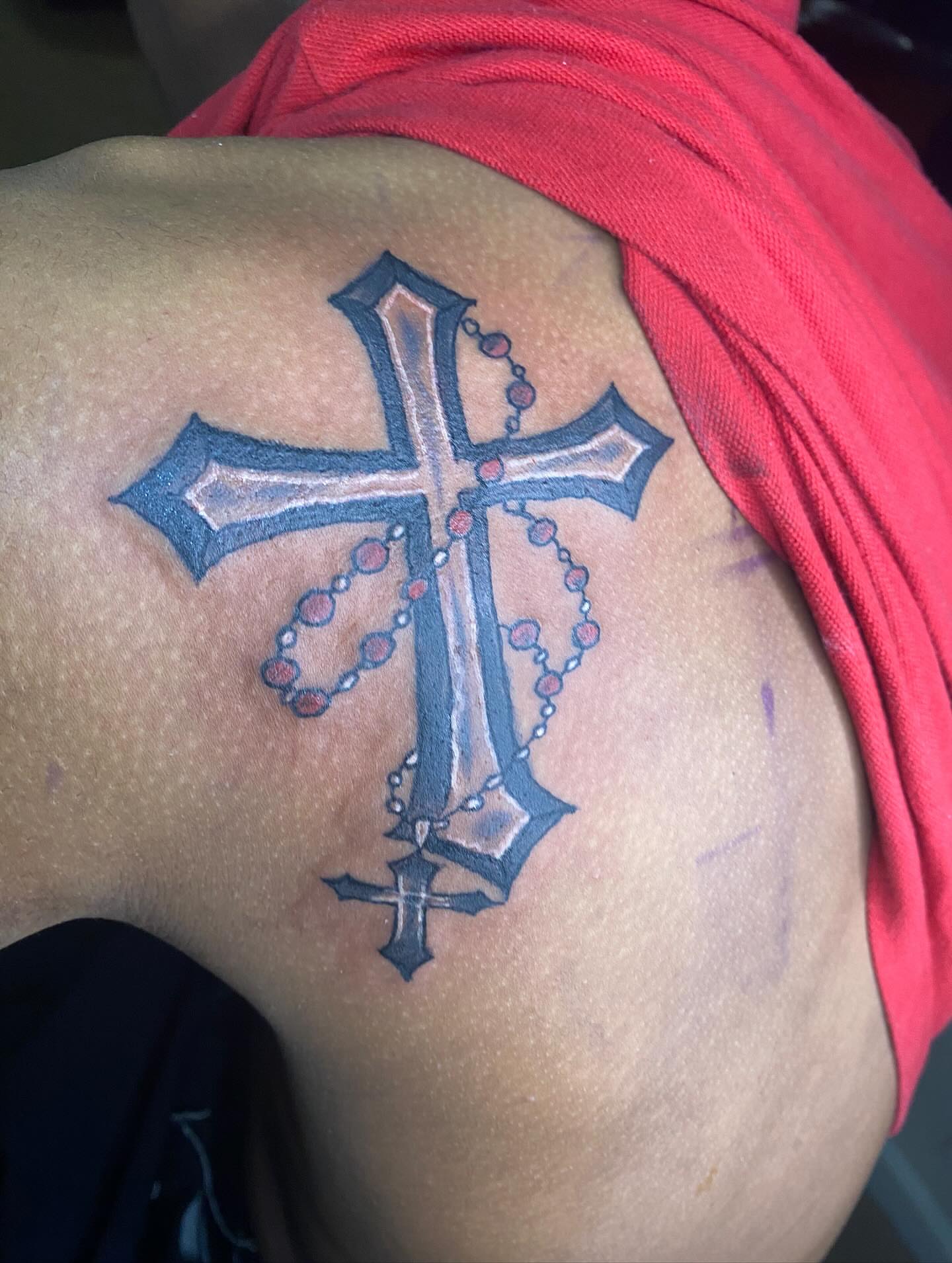 Cross with rosary black and grey tattoo on the shoulder by Illuminink.gallery