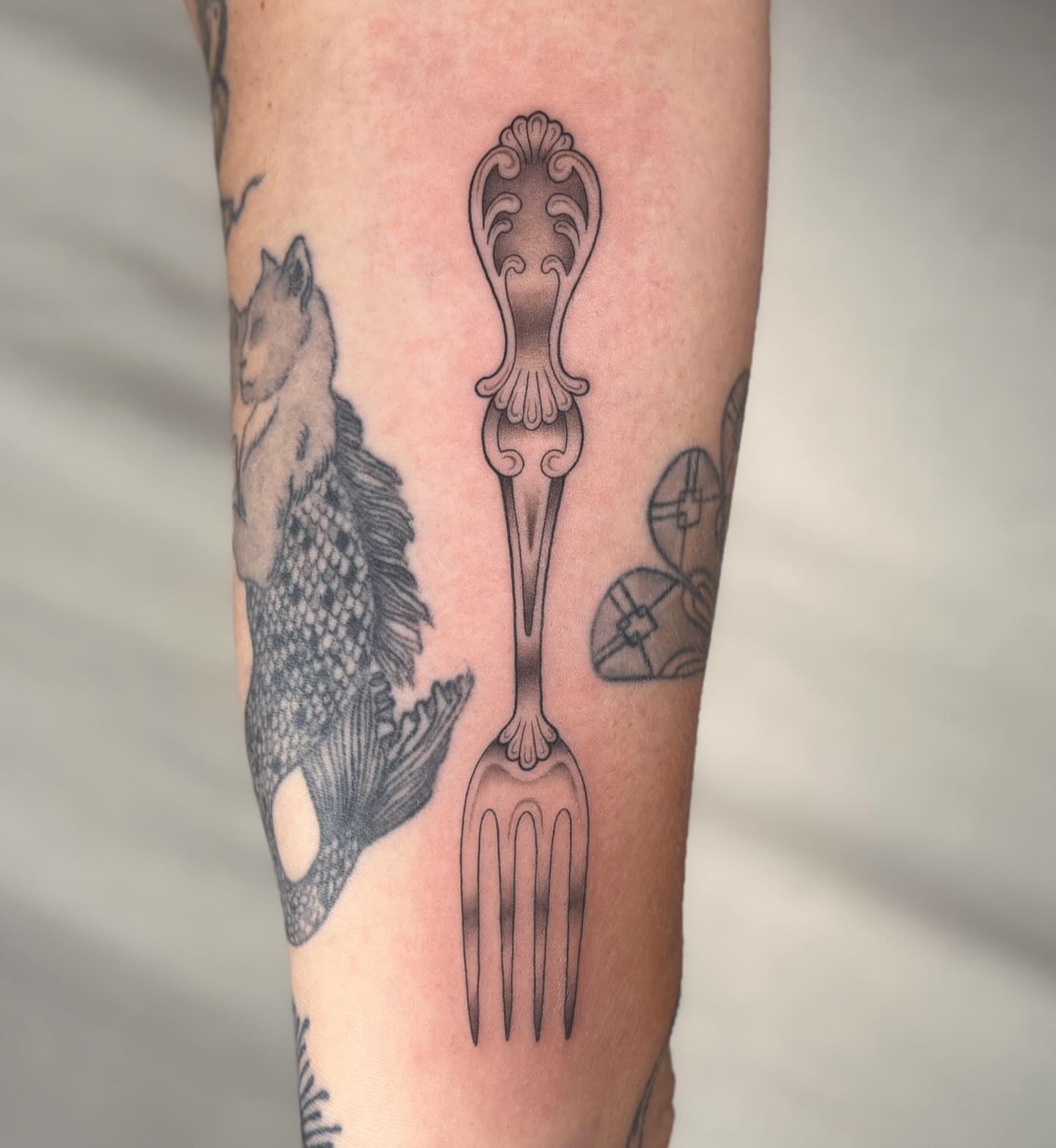 Fork black and grey tattoo on the forearm by Anna Sage