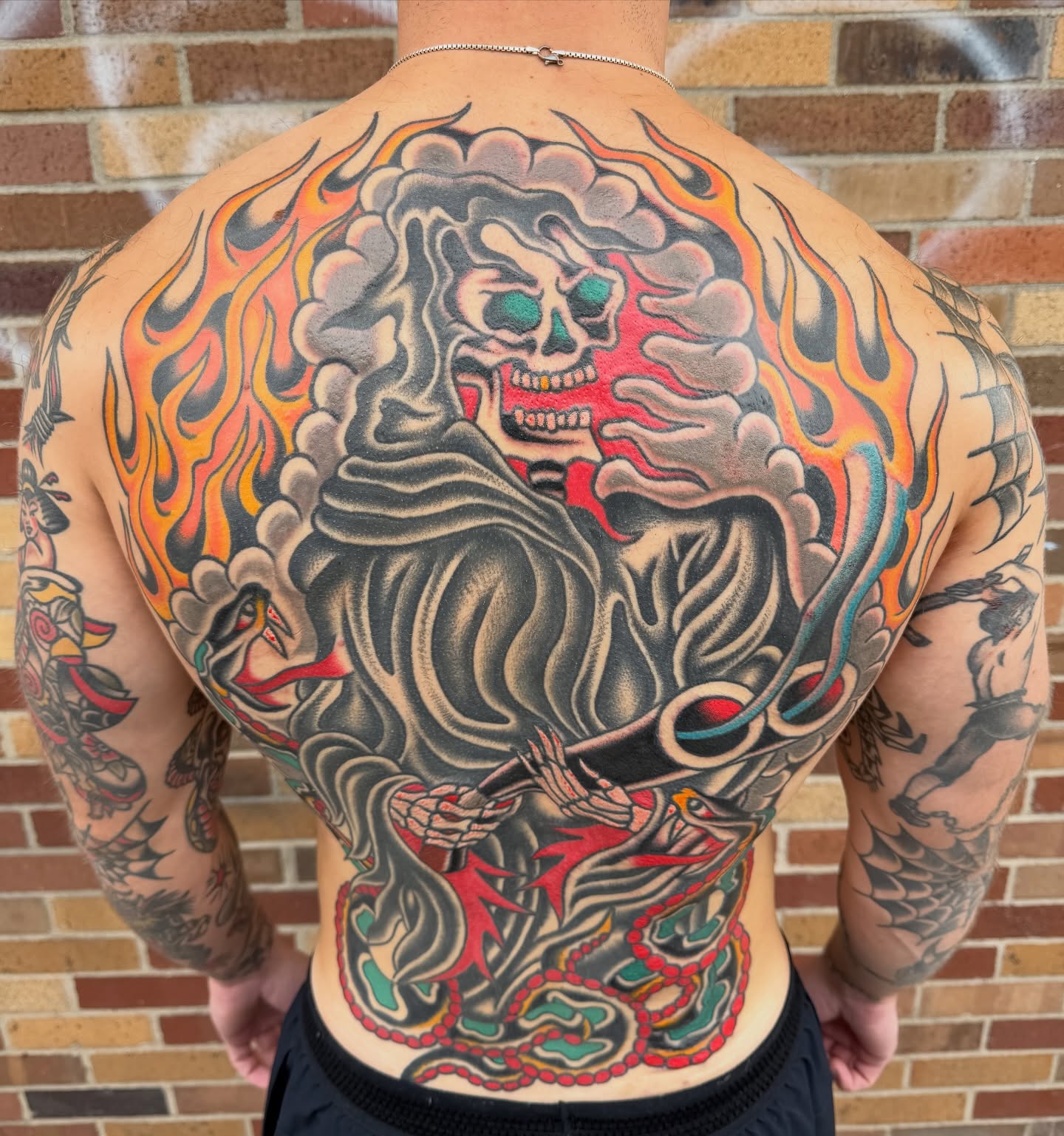 Flaming skeleton American traditional tattoo on the back by Nick Judkins Tattoo