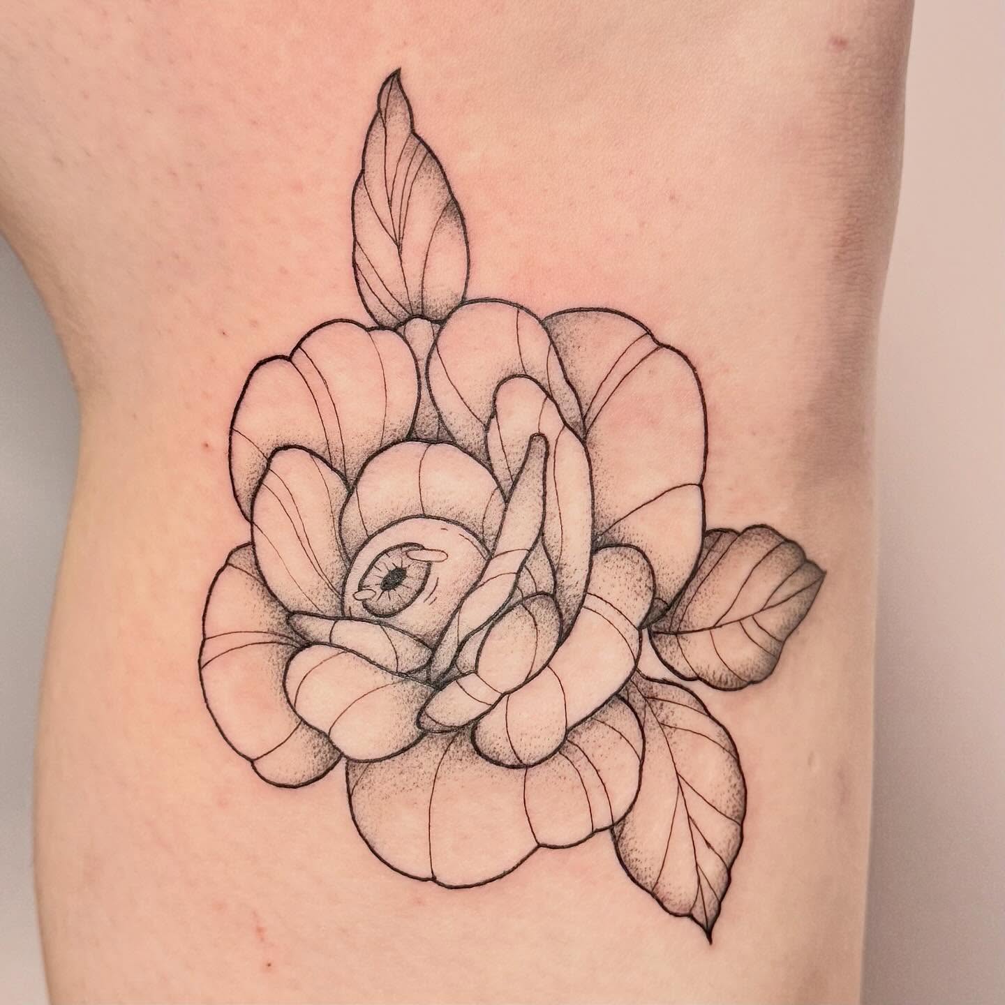 Rose with eye dotwork tattoo on the thigh by Sierra Seton