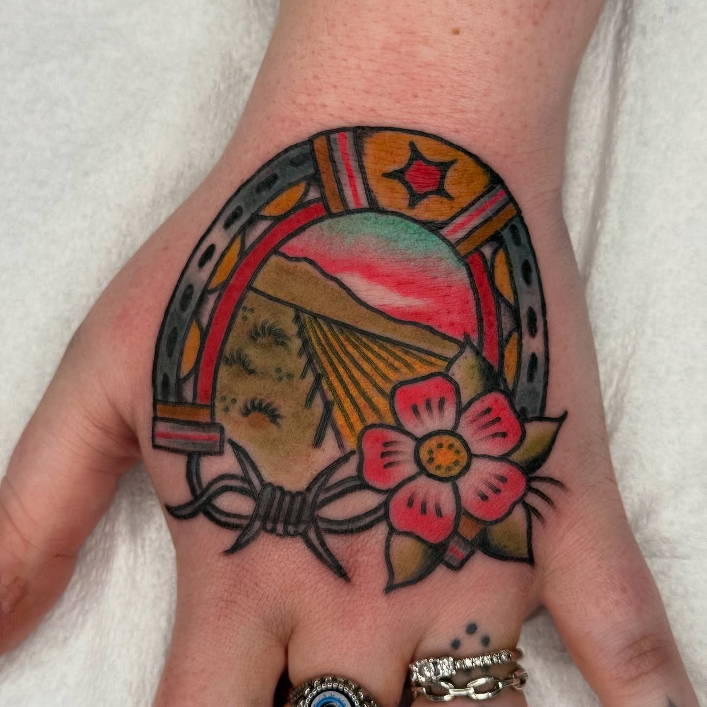 Horseshoe and flower American traditional tattoo on the hand by Sarah Christine Tattoo, Calgary, Alberta