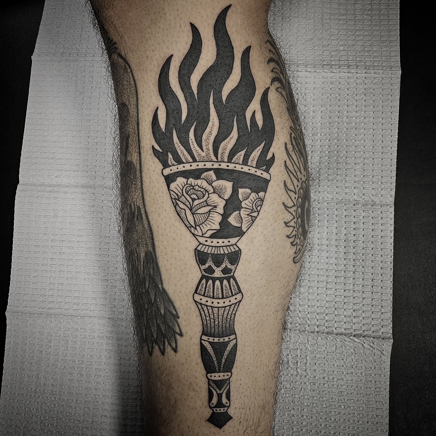 Torch with flames and rose American traditional tattoo on the forearm by Kirk George