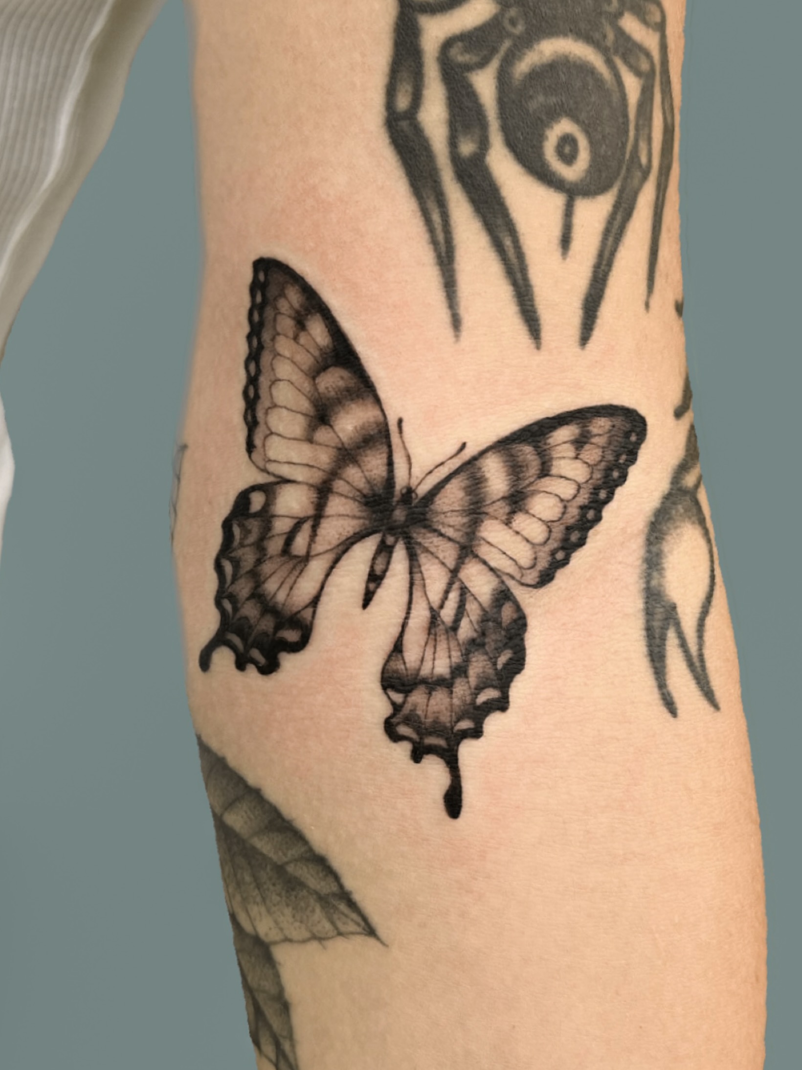 Butterfly black and grey tattoo on the forearm by nina