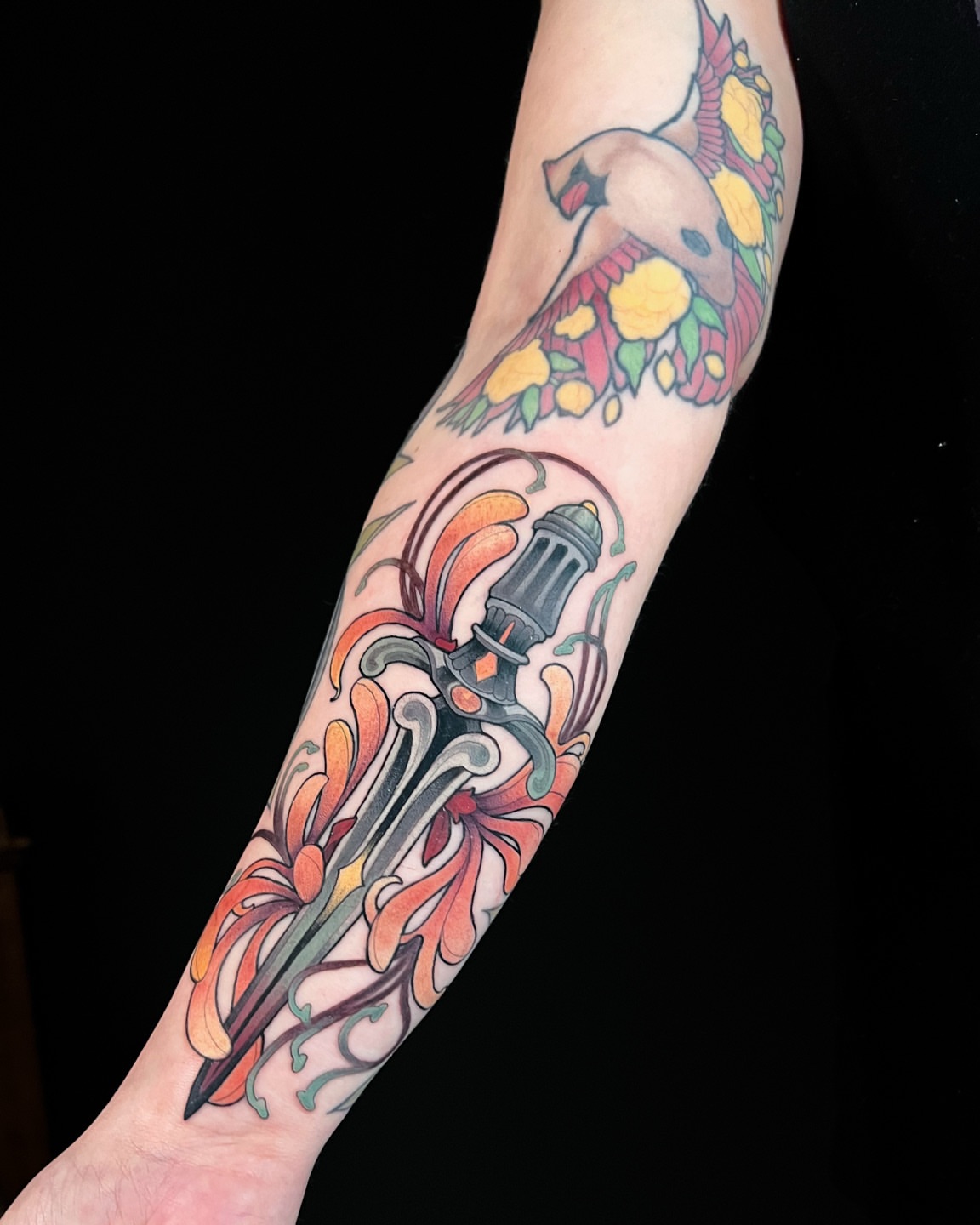 Sword and floral American traditional tattoo on the forearm by Hannah Steele