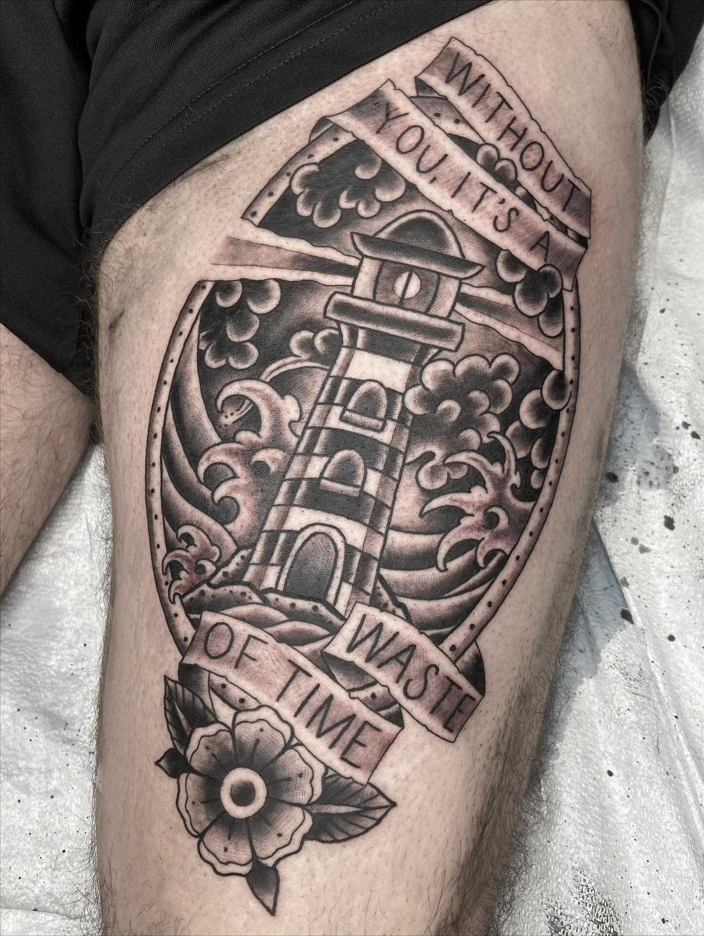 Lighthouse and waves black and grey tattoo on the thigh by nicholas mcevoy, Boston, Massachusetts