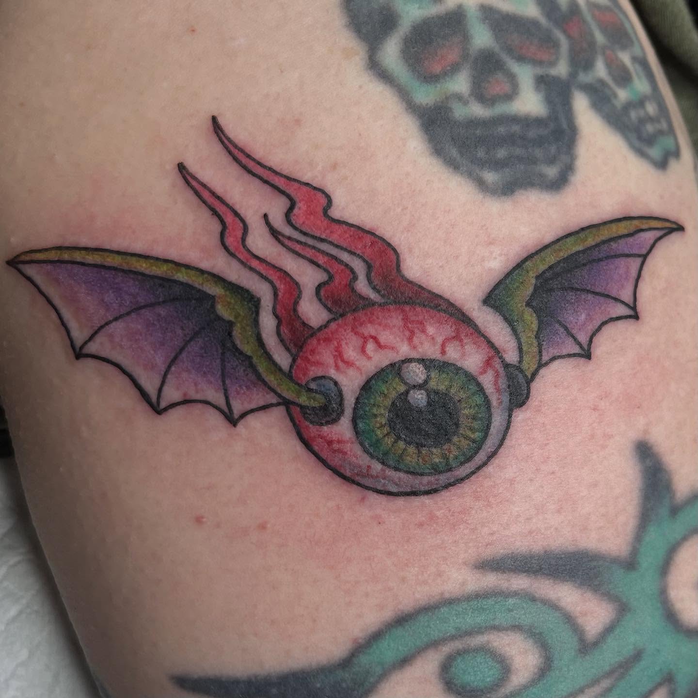 Eye with wings neo-traditional tattoo on the shoulder by Sue Garcia