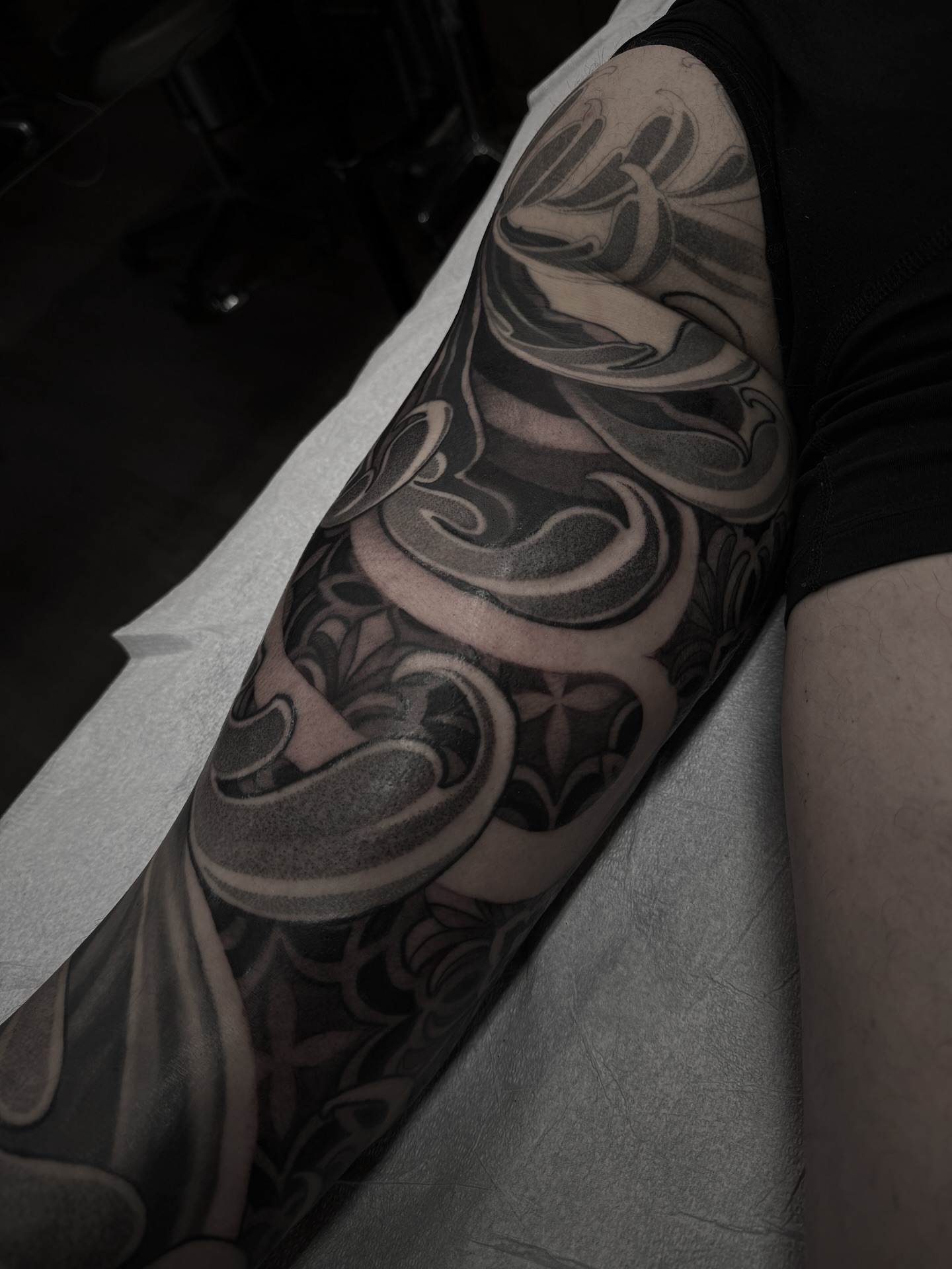 Scrollwork black and grey tattoo on the forearm by gina