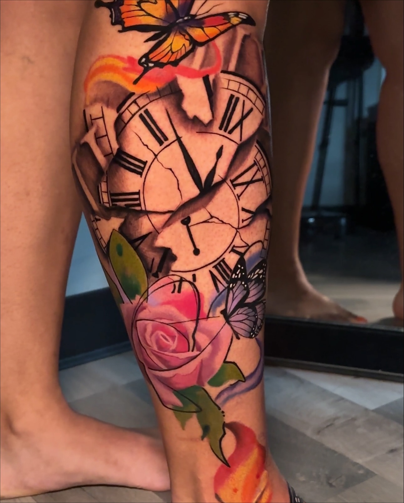 Clock and rose realism tattoo on the calf by Christopher Simmons