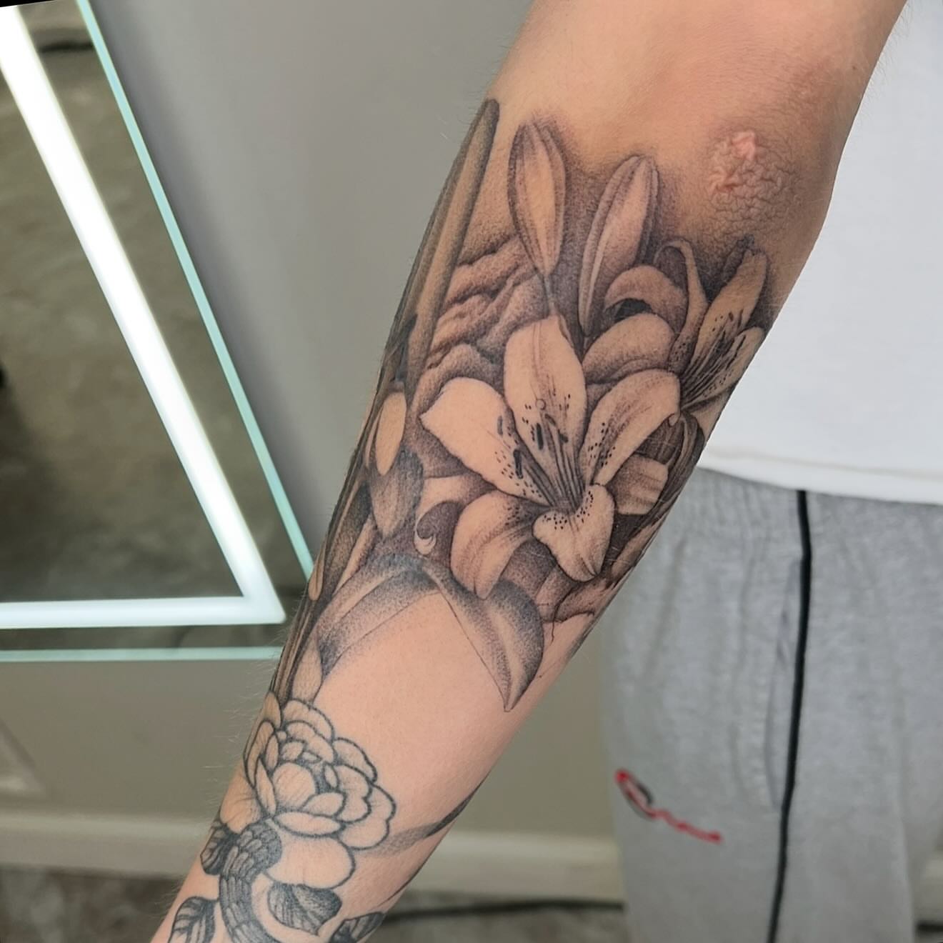 Lilies realism tattoo on the forearm by Jocelyn