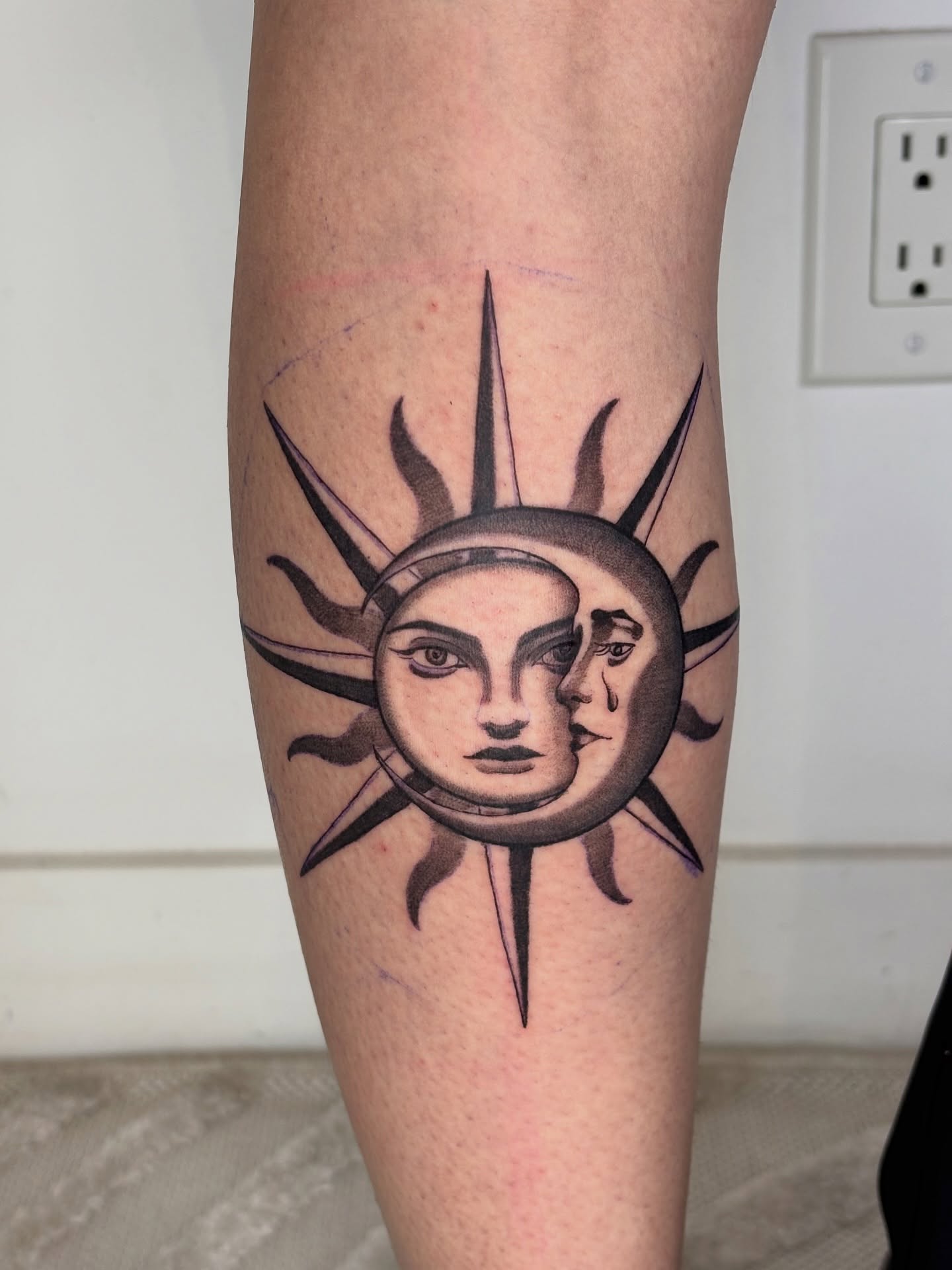 Sun and moon faces black and grey tattoo on the forearm by Dani