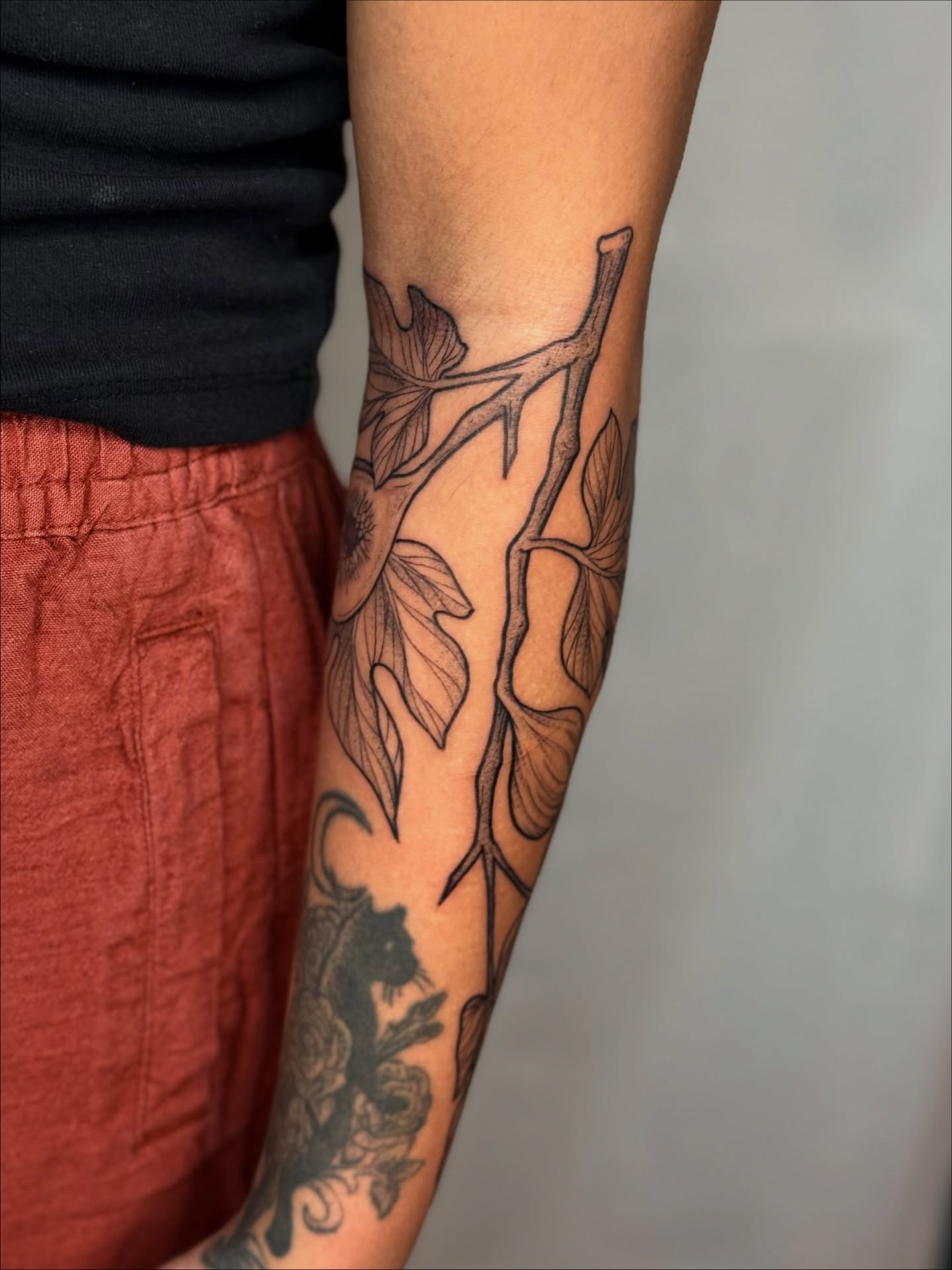 Branch and leaves black and grey tattoo on the forearm by Cooper