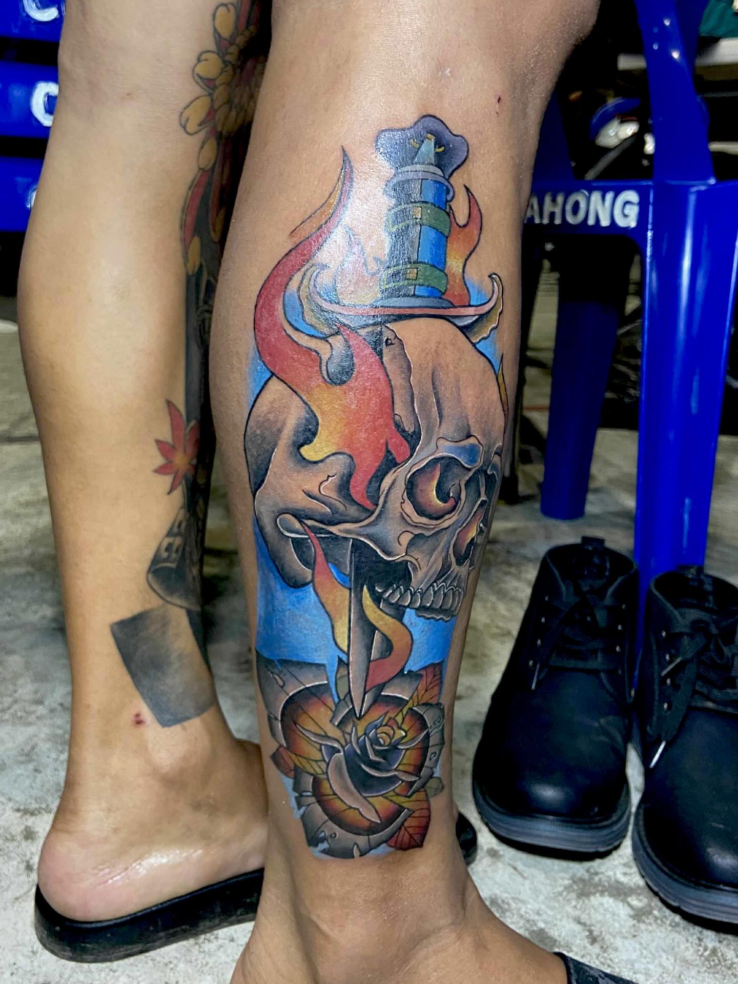 Flame skull with lighthouse American traditional tattoo on the calf by Gerd thINK_TATTOO