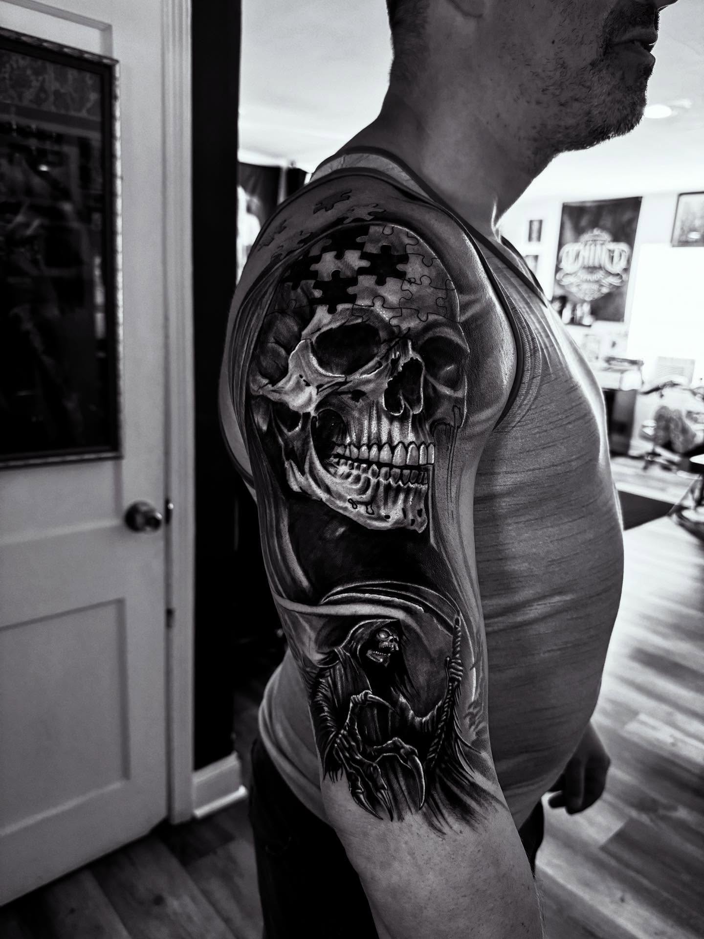 Skull realism tattoo on the upper arm by Miguel Garcia