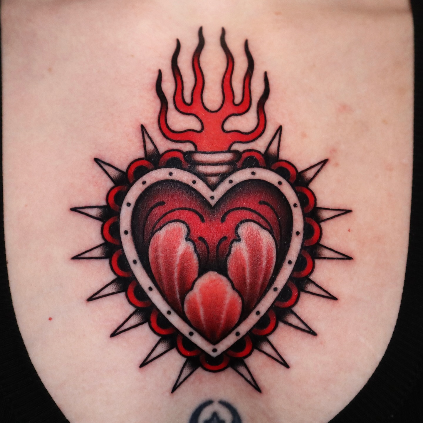 Heart with flames American traditional tattoo on the forearm by Lauren Howard Tattoos