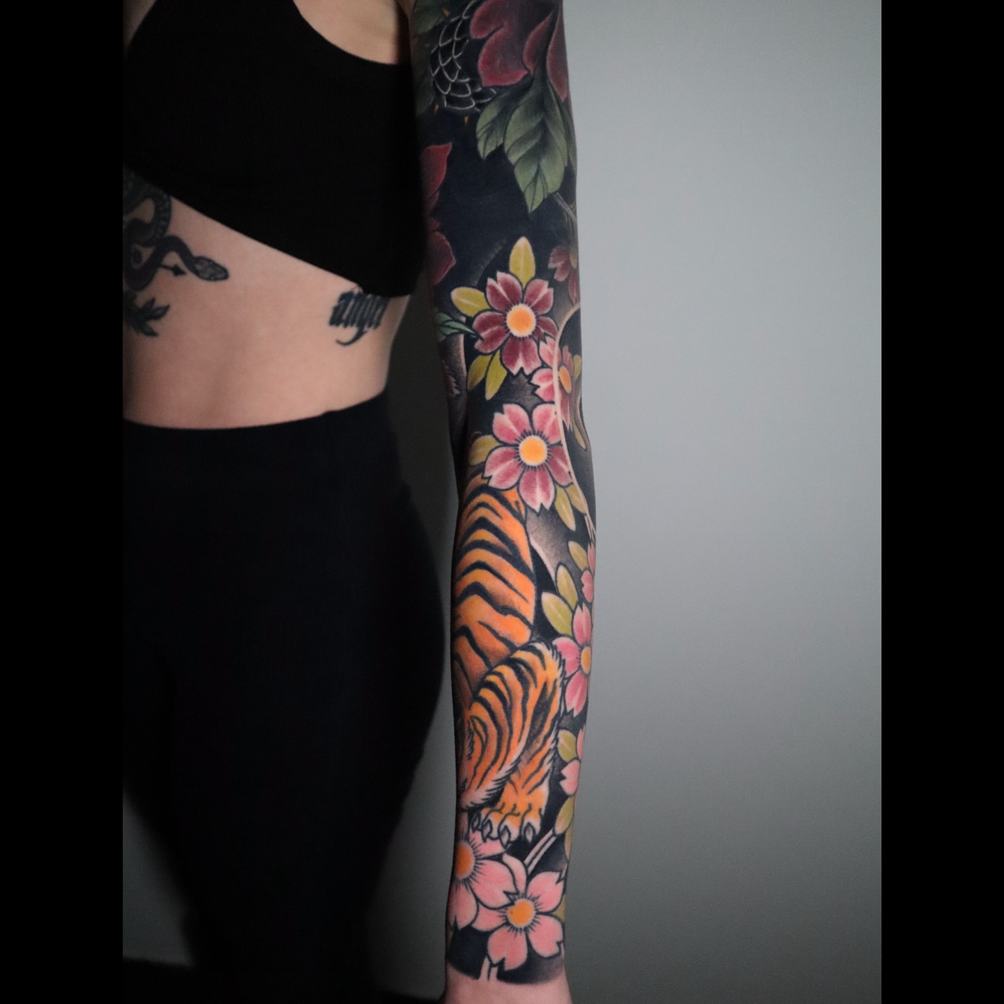 Tiger and flowers American traditional tattoo on the upper arm by Lauren Howard Tattoos