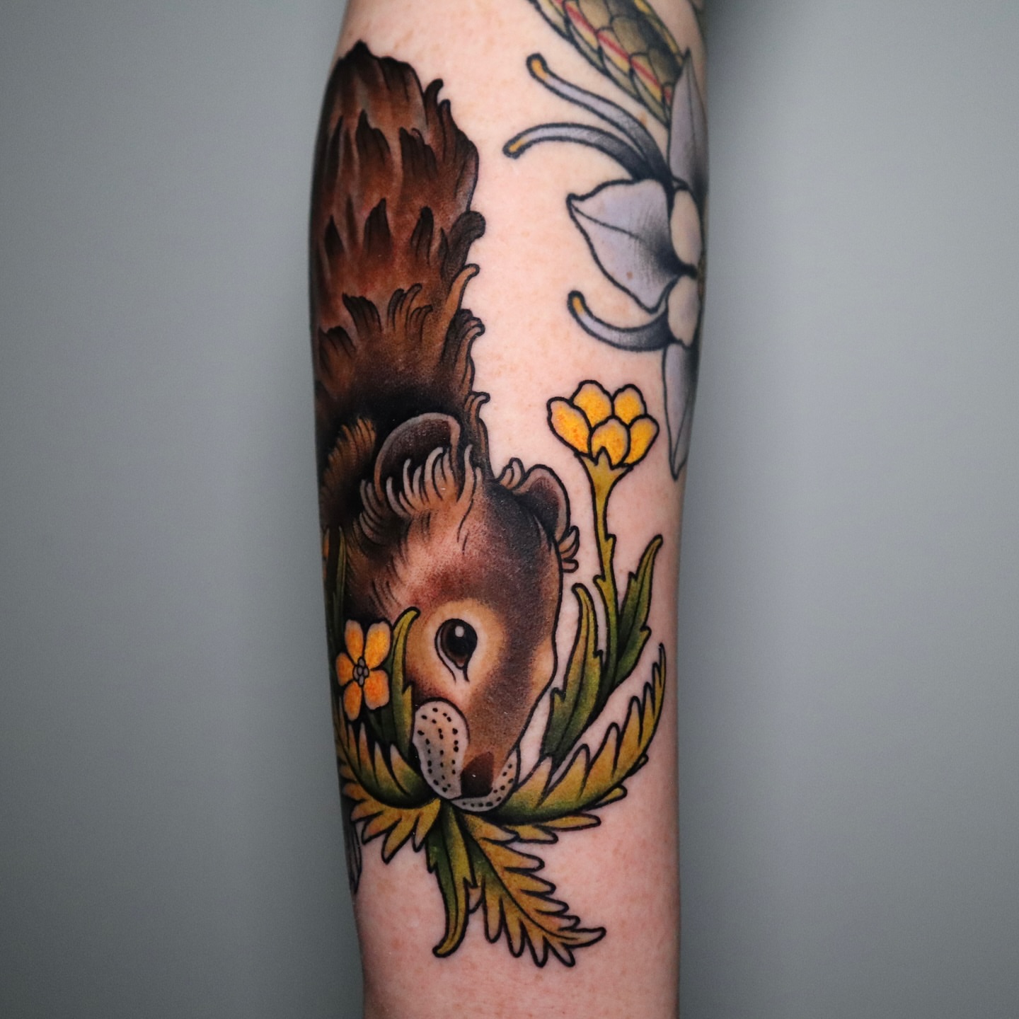 Squirrel and flowers American traditional tattoo on the forearm by Lauren Howard Tattoos