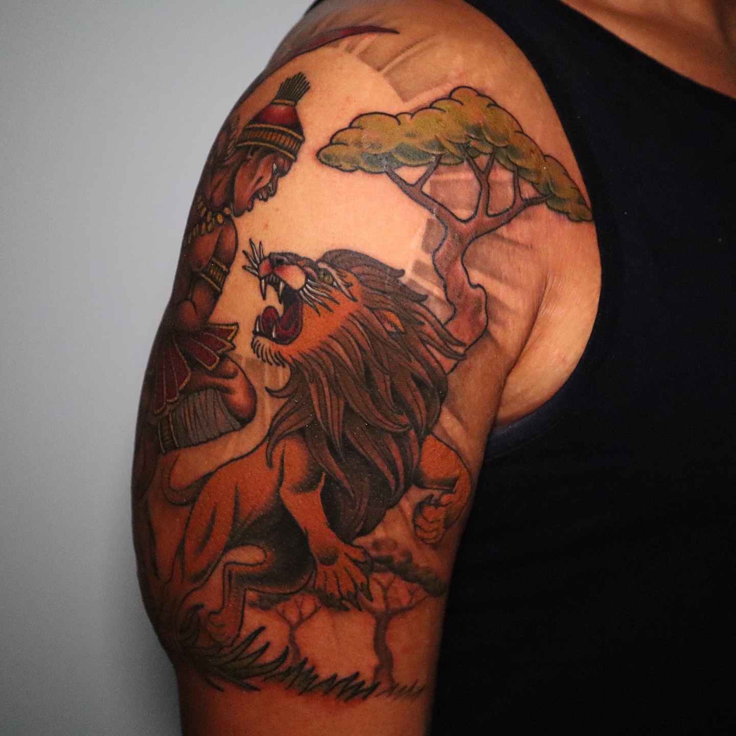 Lion and warrior American traditional tattoo on the shoulder by Lauren Howard Tattoos