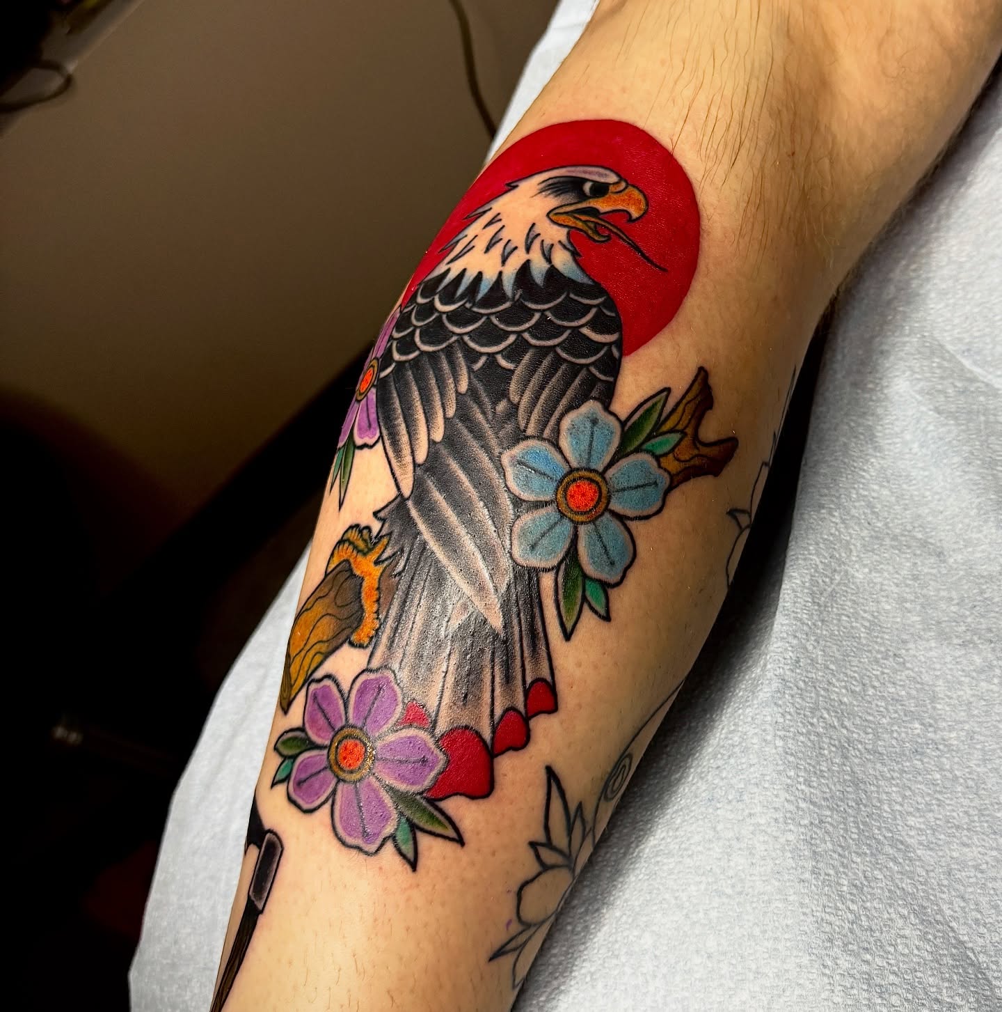 Eagle and flowers American traditional tattoo on the forearm by Derek Cilla, Bethlehem, Pennsylvania