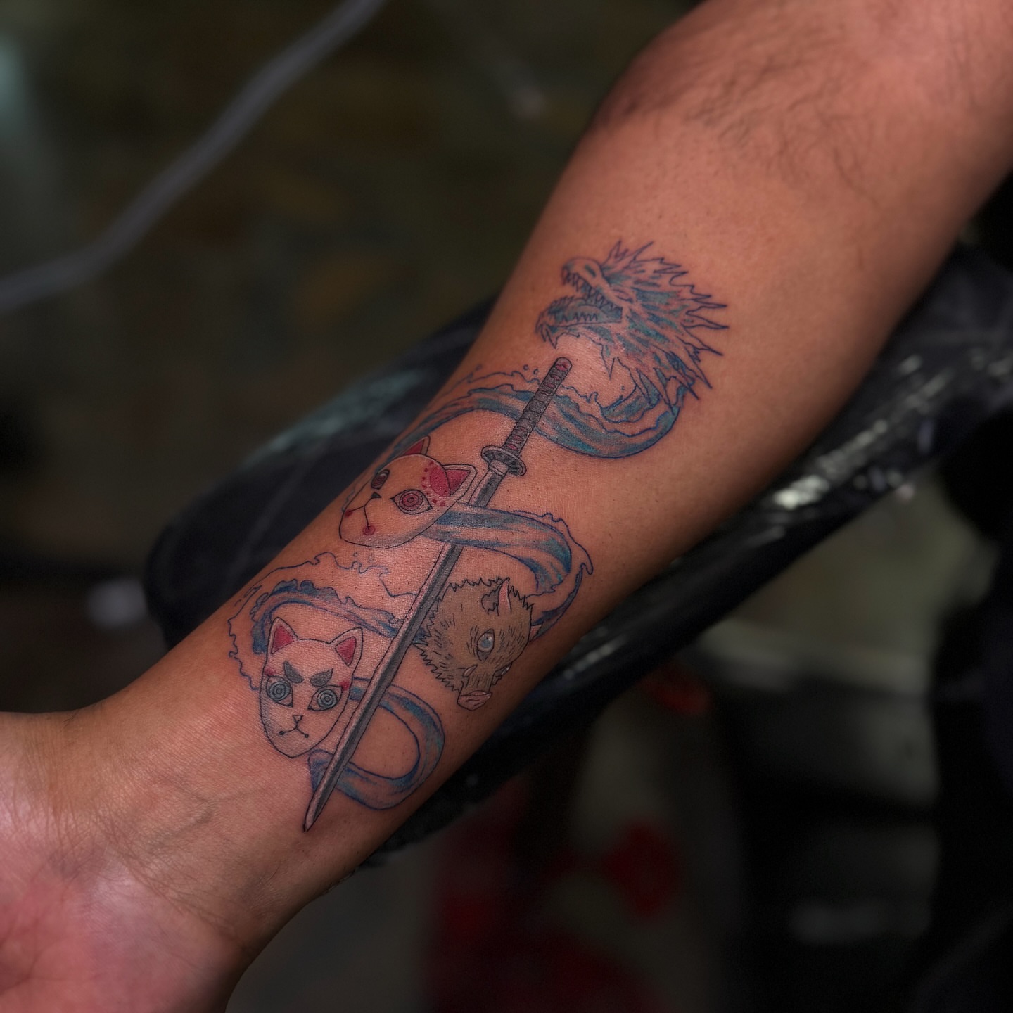 Anime characters with sword anime tattoo on the forearm by Yohana Vargas
