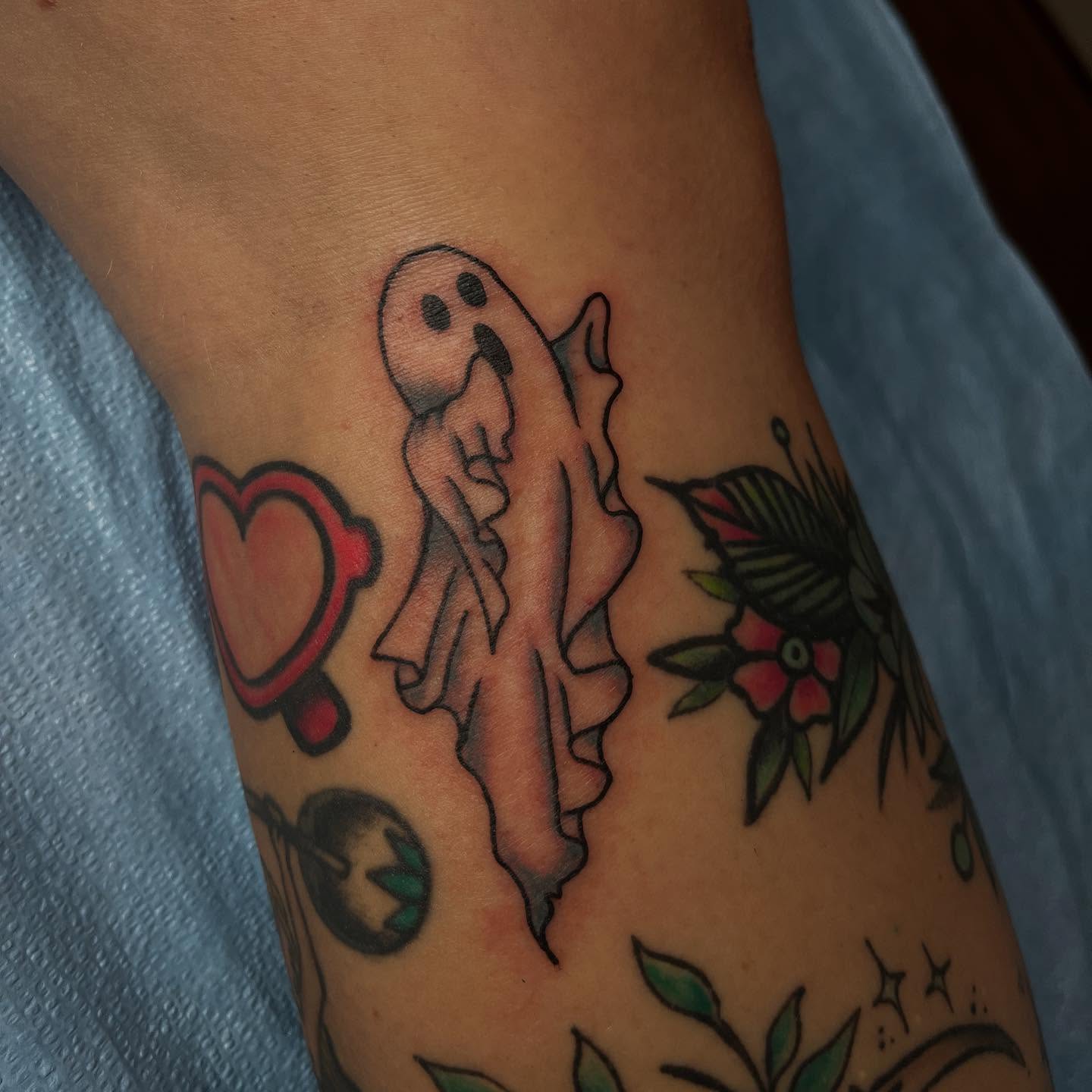 Ghost and heart American traditional tattoo on the forearm by Mariah Nguyen