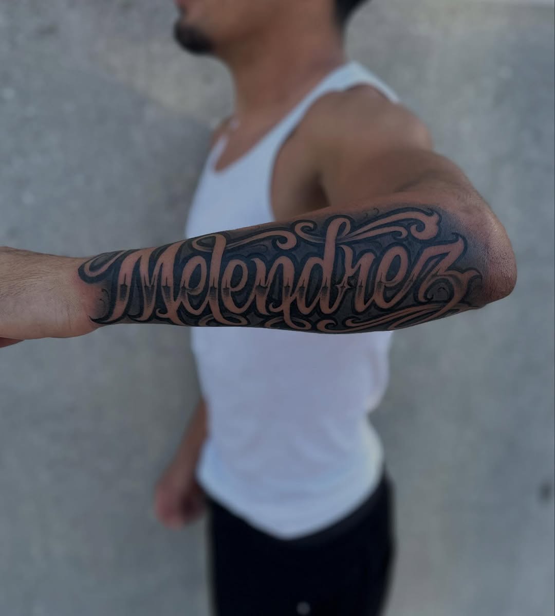 Melendrez script lettering lettering tattoo on the forearm by Ruben