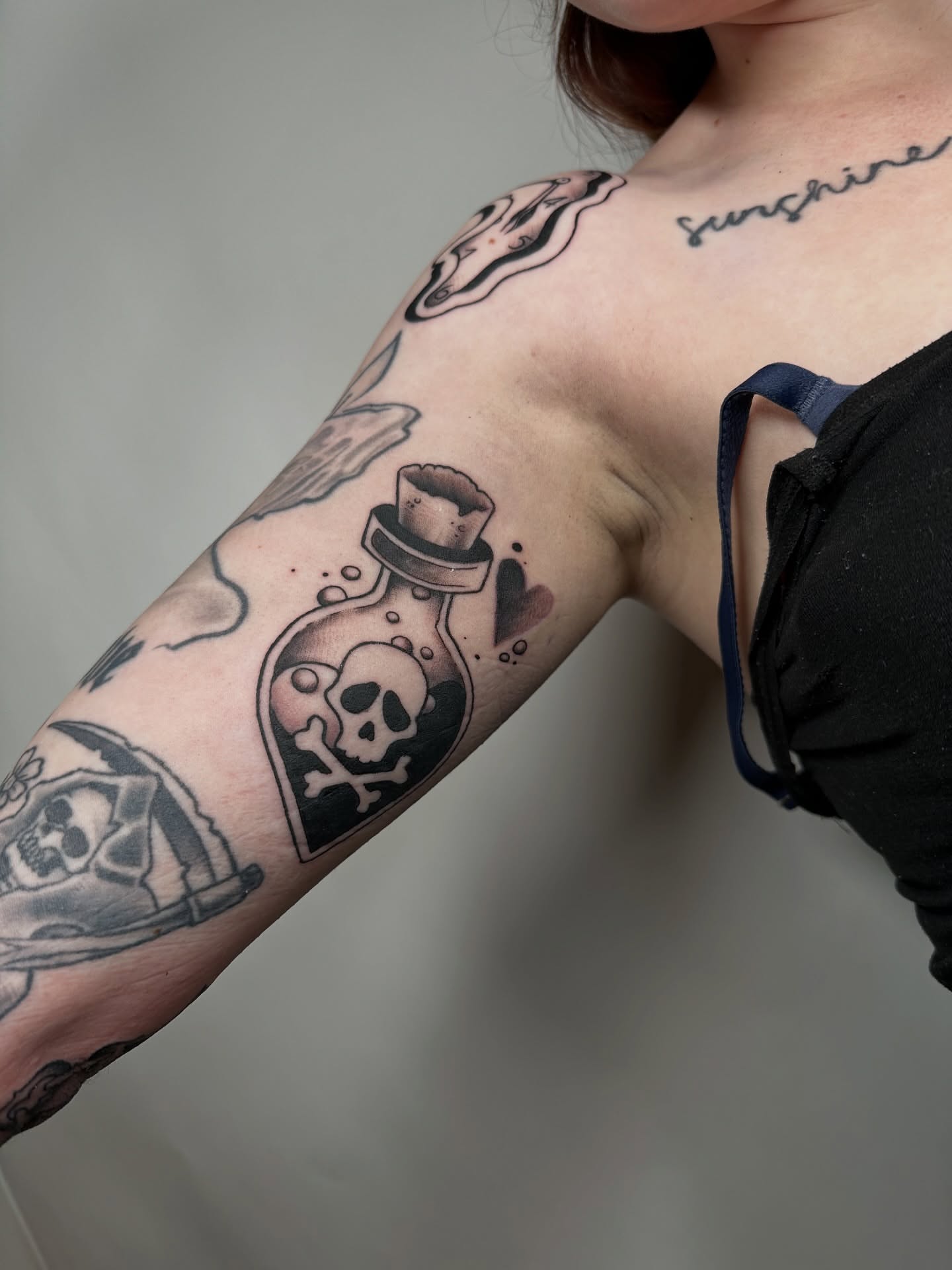 Skull in bottle black and grey tattoo on the forearm by Heather Cherish
