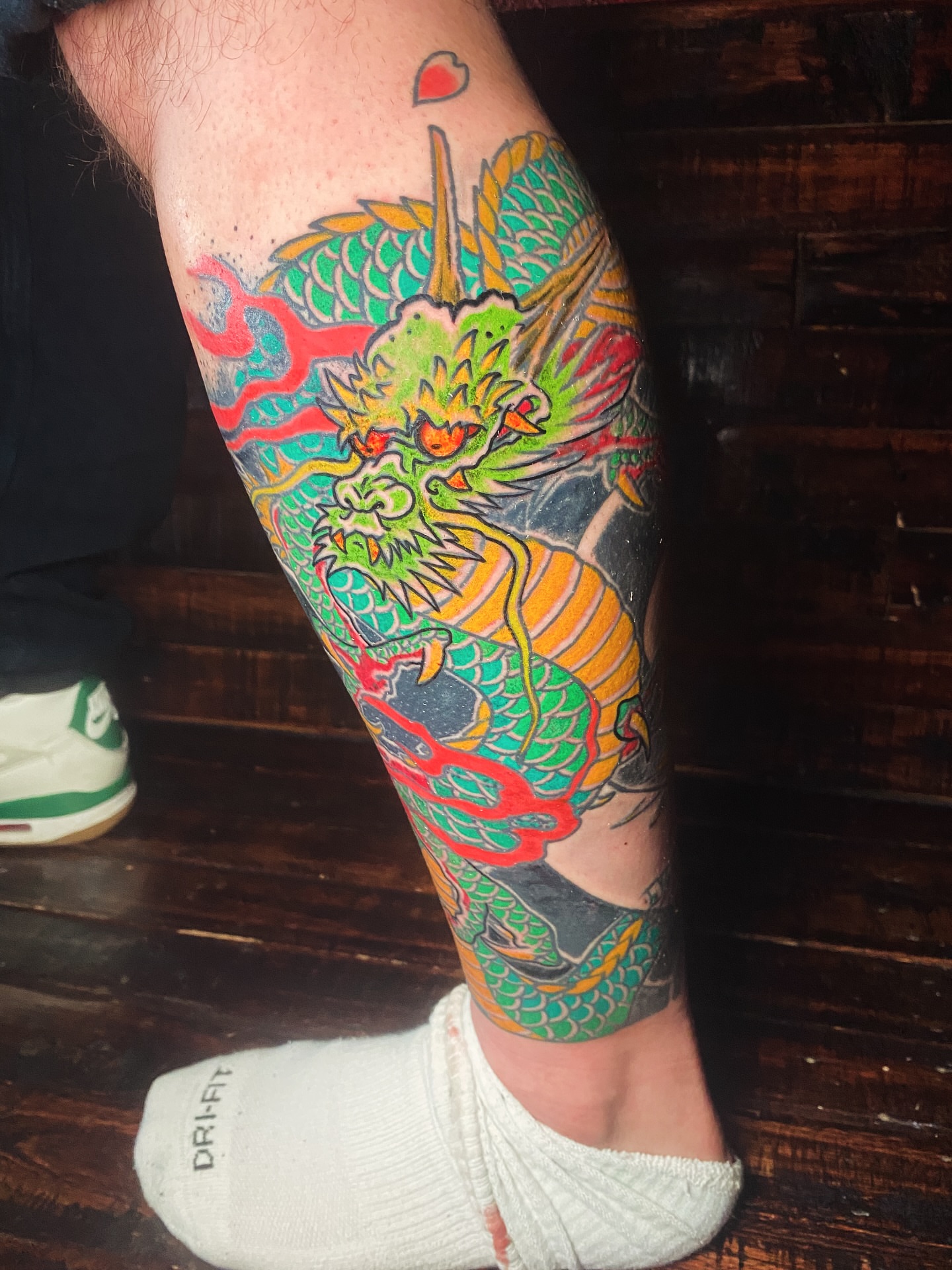 Dragon American traditional tattoo on the calf by Nick Weaver