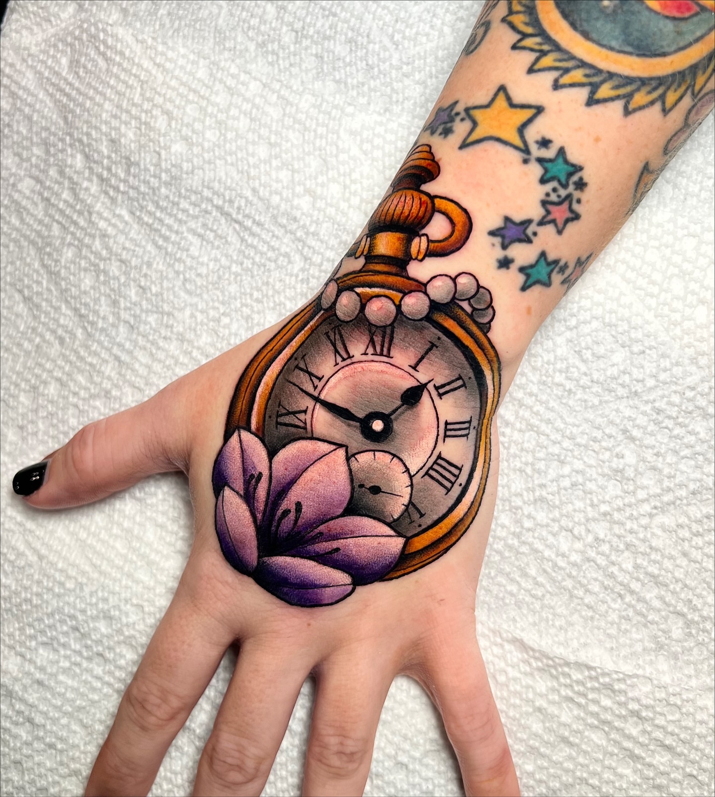 Pocket watch and flower realism tattoo on the hand by Nick Monastra