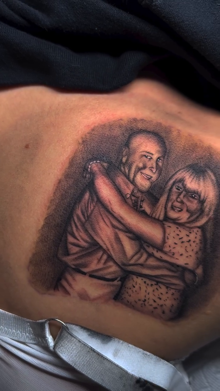 Elderly couple embracing realism tattoo by Tat by Brendan