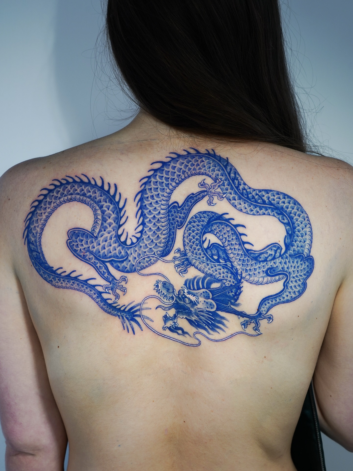 Dragon black and grey tattoo on the back by Swani