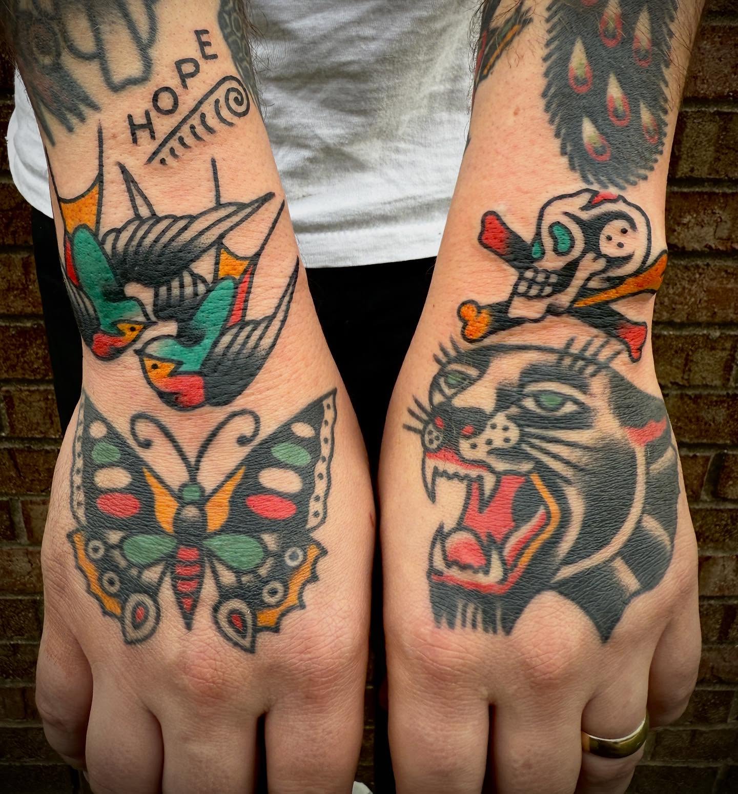 Bird, butterfly, tiger, skull American traditional tattoo on the hand by Tristan Bradshaw